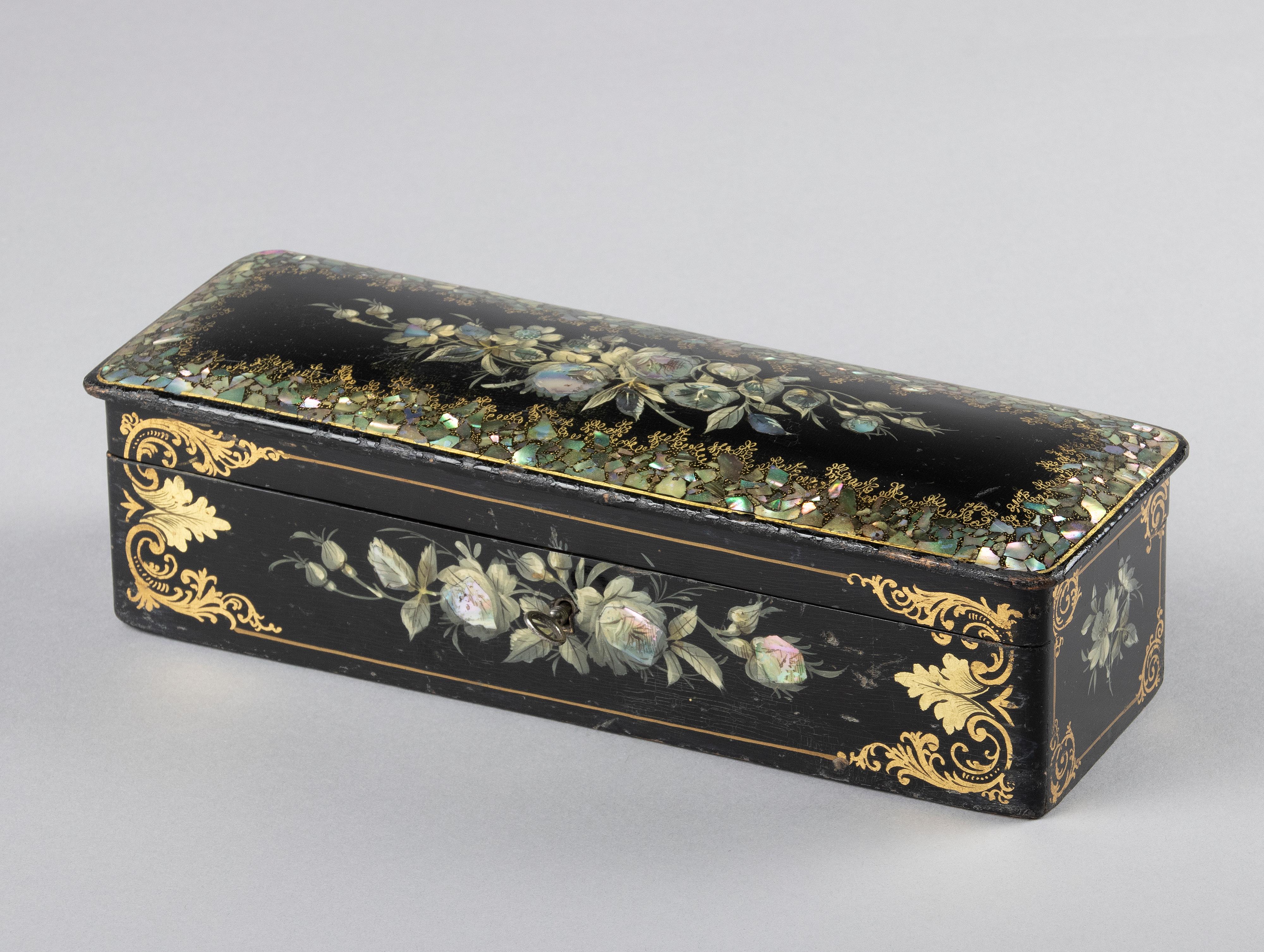 Beautiful antique box from the Victorian style period. The box is made of black lacquered wood, hand painted with gold flowers and inlaid with mother-of-pearl. The inside of the box is lined with pink silk.
The box has normal signs of use and age