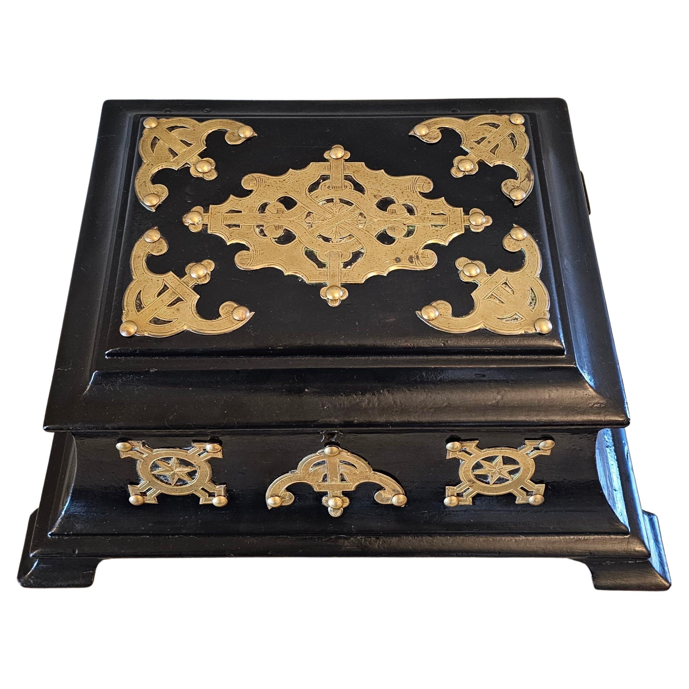A large antique English Victorian era brass-mounted papier-mache dressing box.

19th century, England, large shaped casket form, exterior in a black lacquered finish embellished with ornate riveted and incised brass mounts. The hinged-lid top