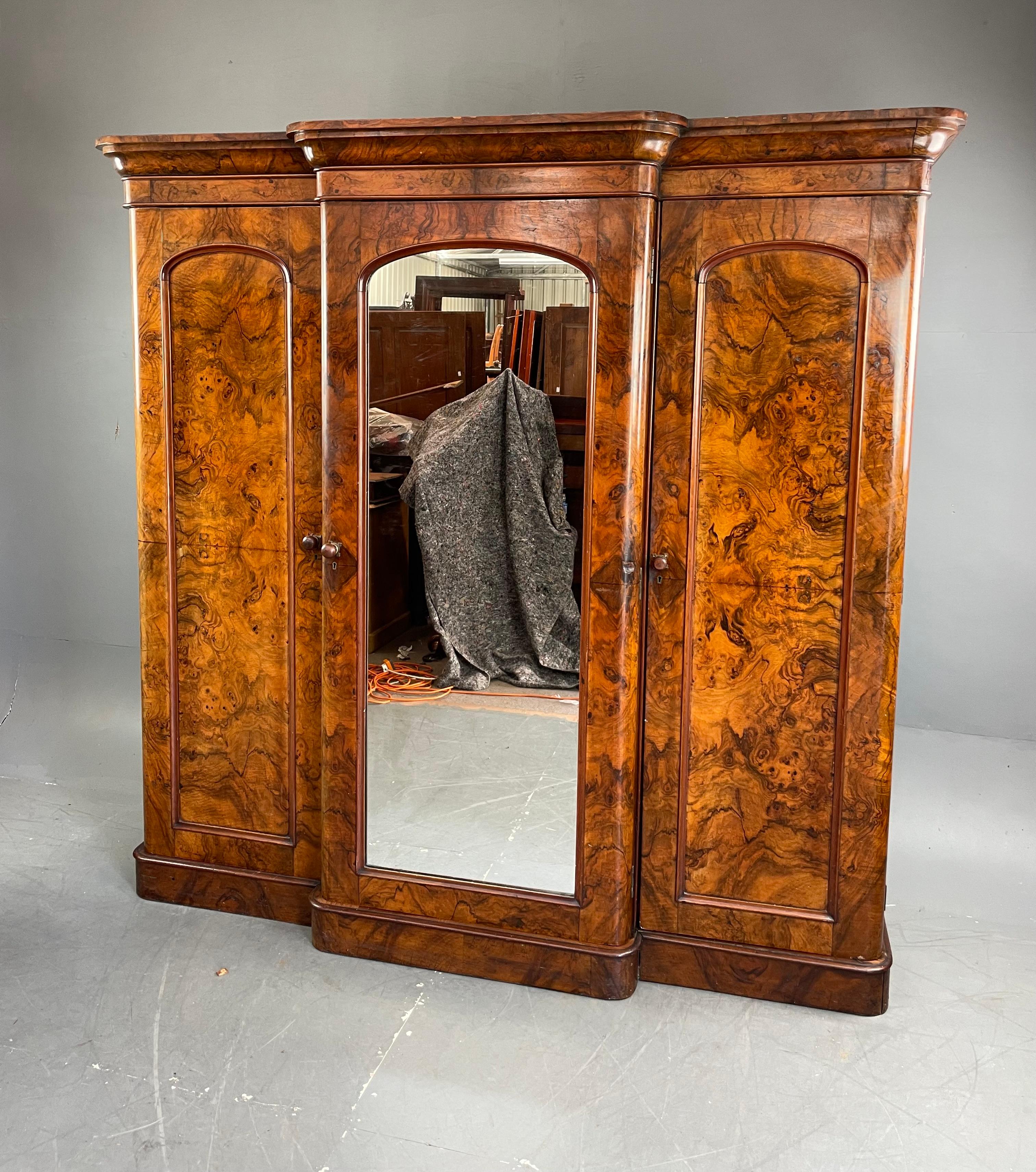 Fine quality Victorian breakfront triple wardrobe circa 1860 .
The wardrobe is very well proportioned and has a wonderful grain and colour .
The wardrobe has two hanging sections fitted with rails and hooks the right section has shoe storage to the