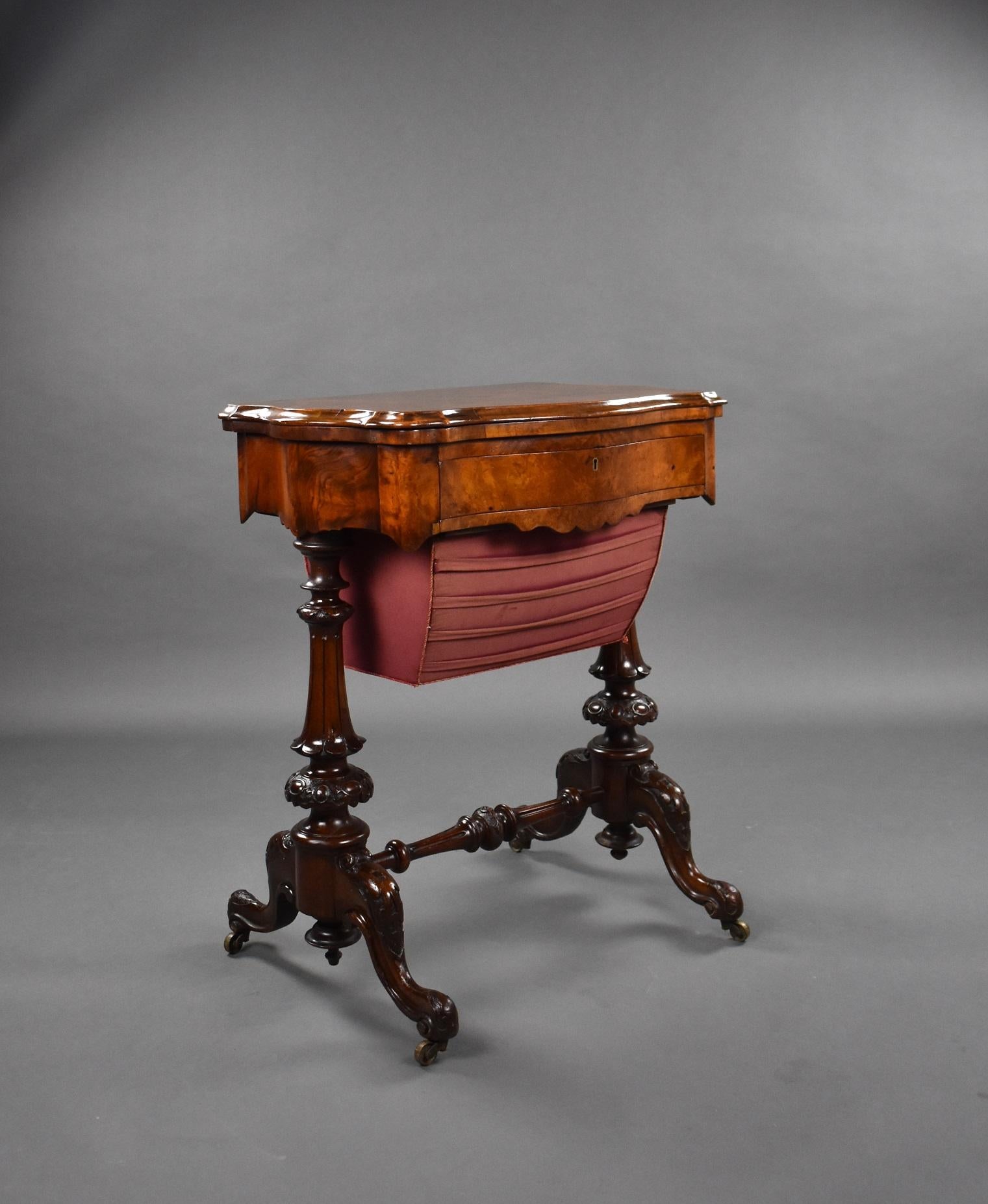 A good quality Victorian burr walnut work table / games table. The top of the table swivels and folds over to reveal a board for chess and for back gammon. Below this is a fitted drawer, above a pull out basket. The table has ornately carved legs