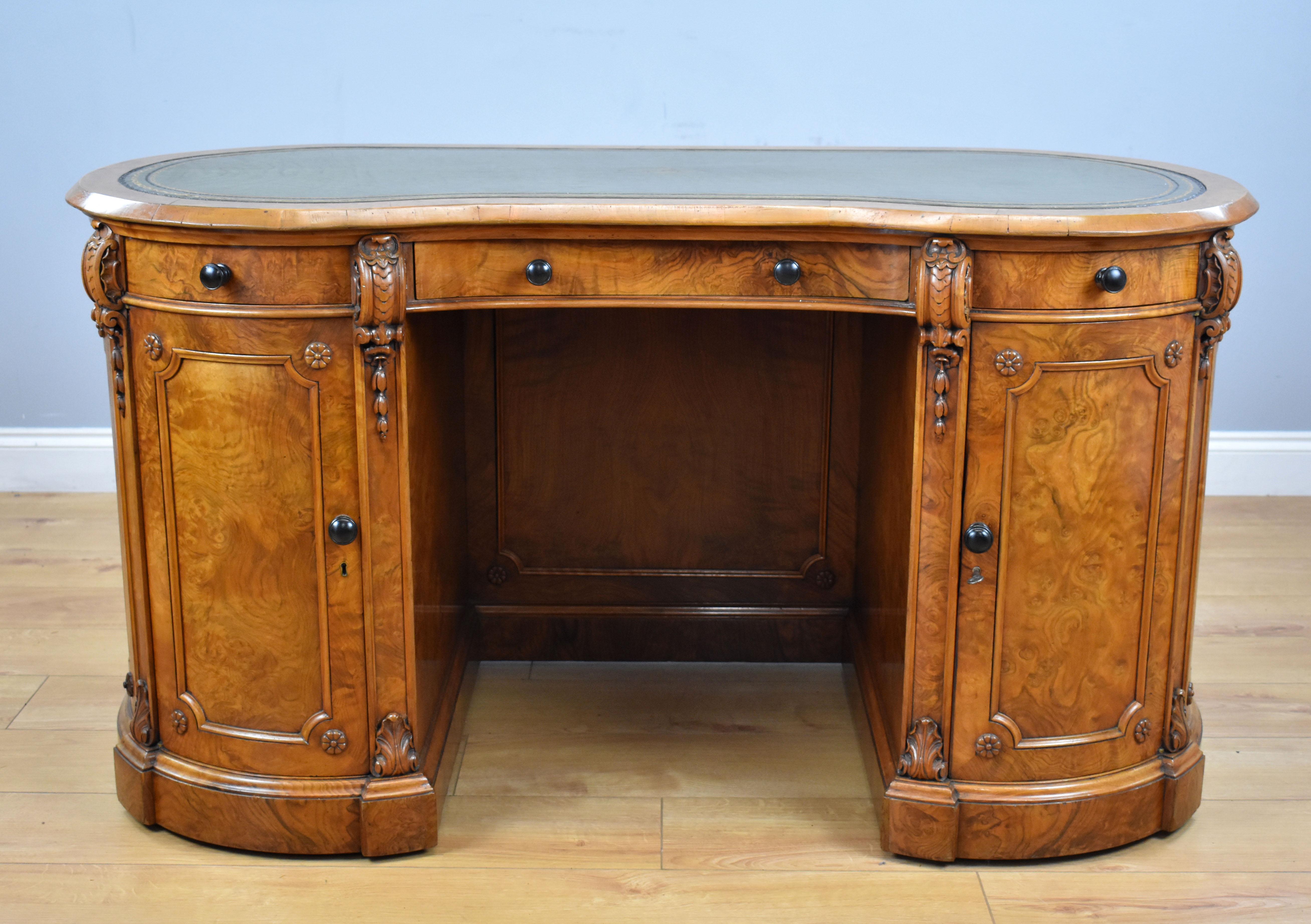 A top quality Victorian burr walnut kidney shaped desk in the manner of Gillows. The top having a green leather top decorated with gold tooling and motifs, above three drawers over two cupboards, one opening to reveal drawers, the other shelves.