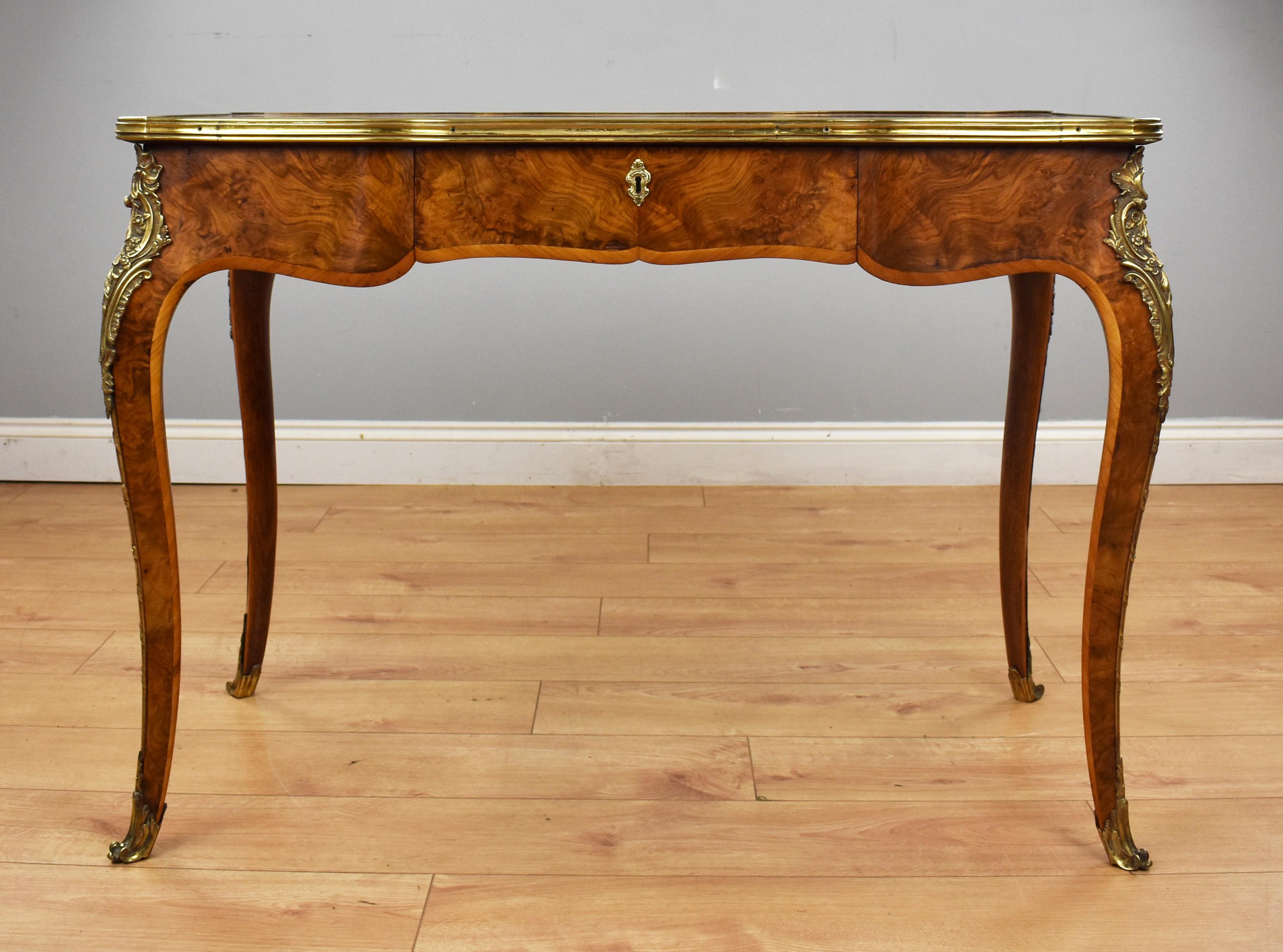 For sale is a fine quality mid Victorian Louis XV style burr walnut writing table, having a shaped quarter veneered top inlaid with a scrolled foliate border above a shaped frieze with a single drawer, standing on elegantly shaped legs the piece is