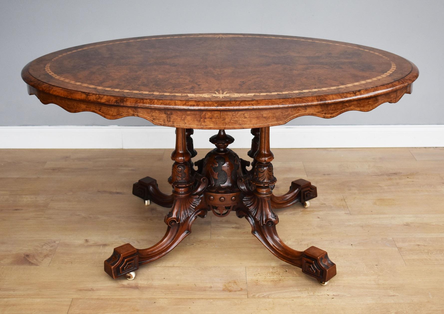 For sale is a good quality Victorian burr walnut breakfast table, having a well figured top with fine inlays to the edge. Below this, the table has a superbly carved birdcage base, with ornately columns, central finial and fine decorative carvings.