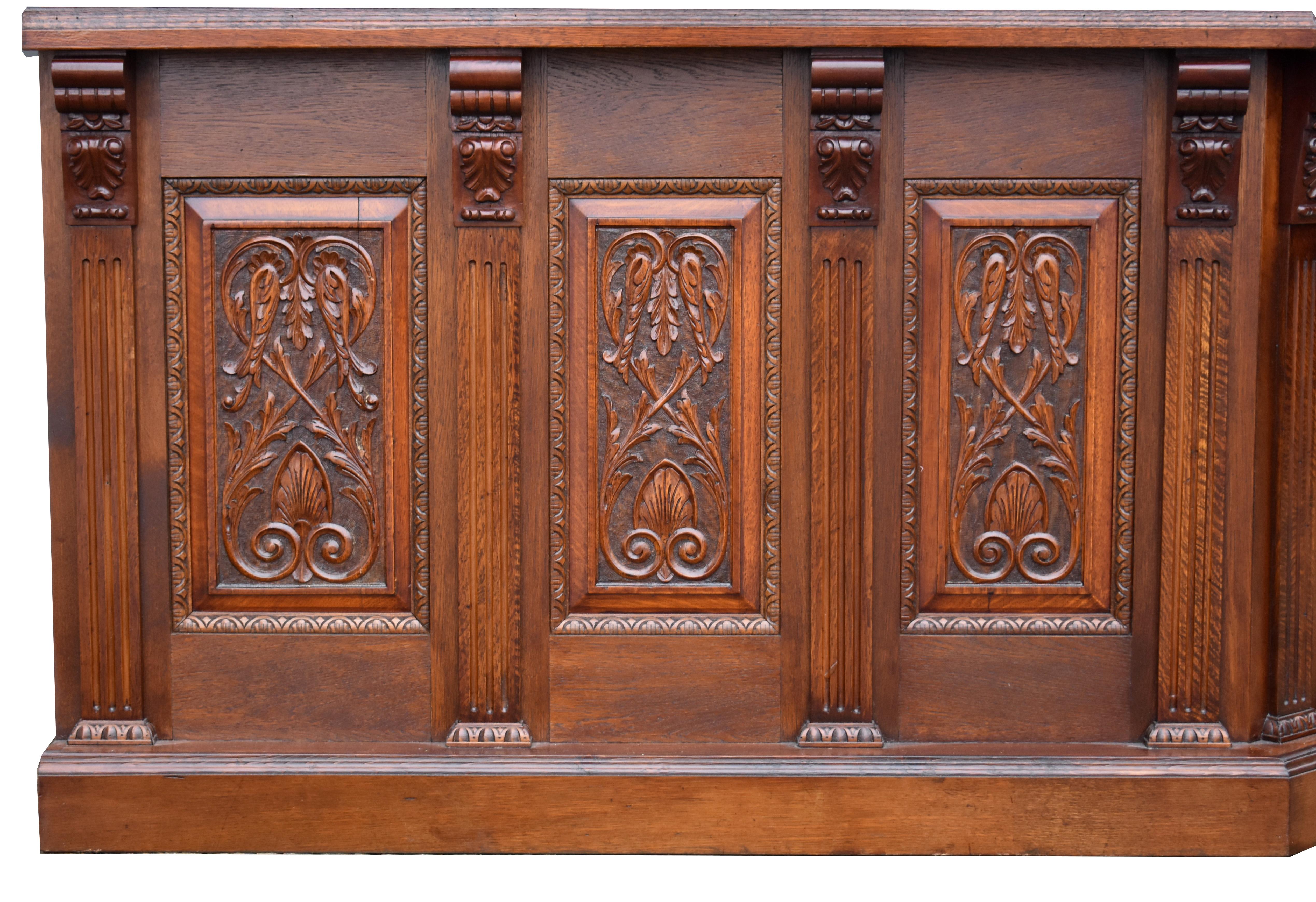For sale is a carved oak canted corner home bar, having a stained glass ceiling, above a beveled mirror in each back flanked by carved panels. Both the front and back counters have carved panels. Overall, the bar is in good condition having been