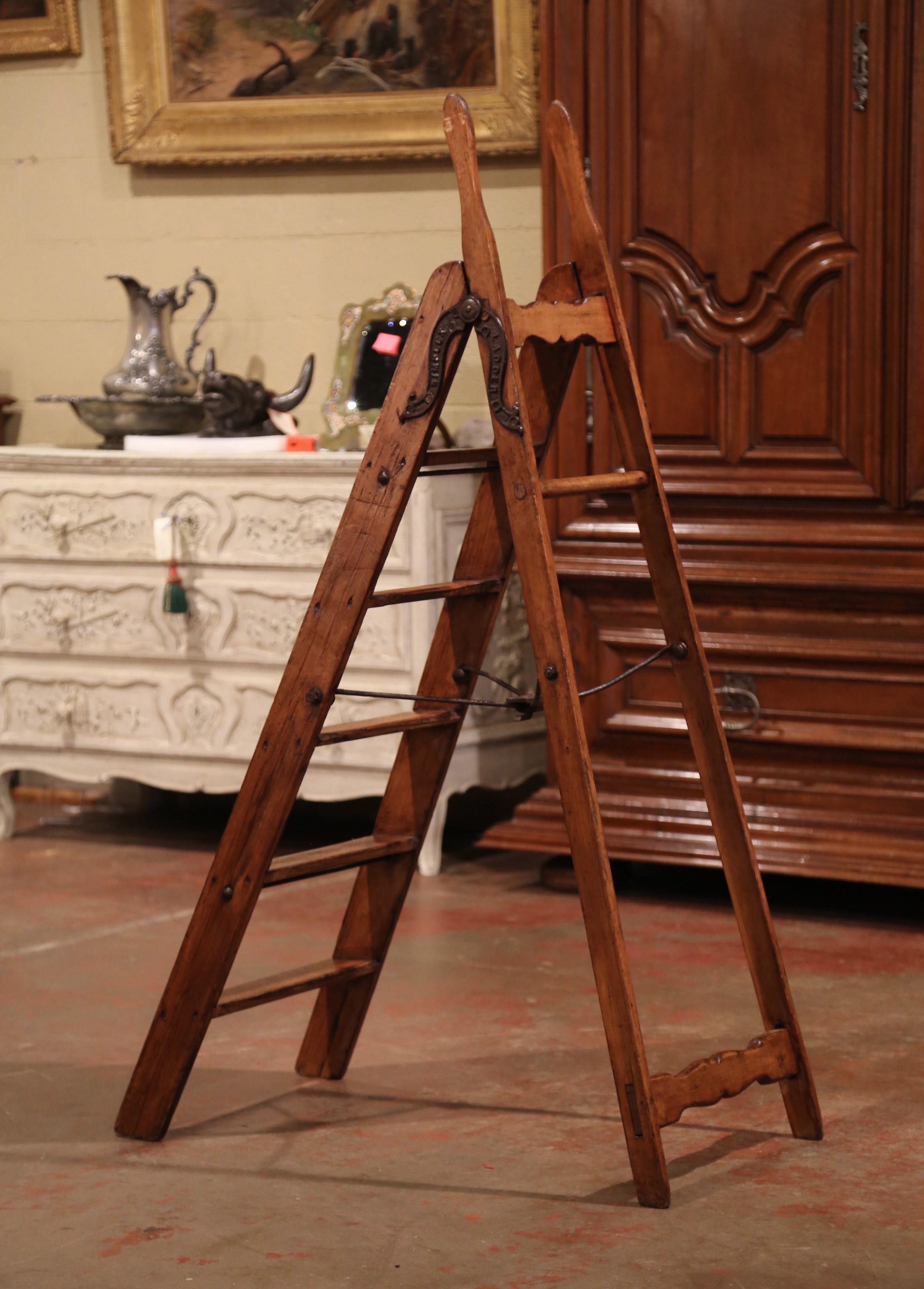 Decorate a study or a library with this whimsical antique ladder. Crafted in England circa 1880 and made of pine, the scalloped stairs features six graduated steps to one side and connected to the opposing support with cast iron patent action