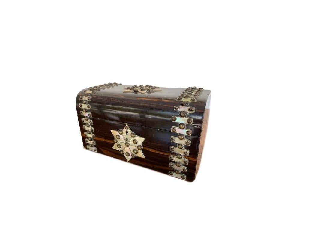 English Victorian cormandel tea caddy decorated with mother of pearl and brass studs, circa 1850s. Cormandel was considered one of the most luxurious woods and only used on the finest of pieces, now extremely rare to find. Original hand tooled