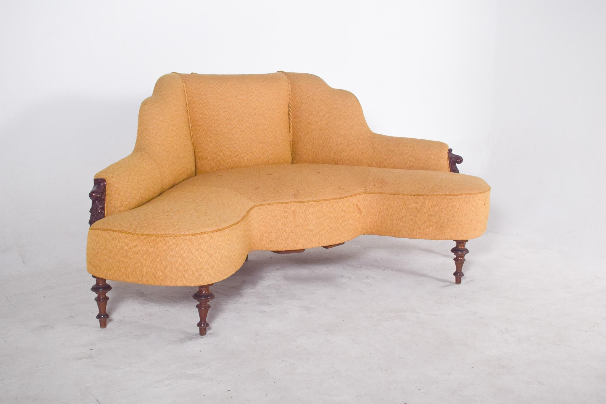 Victorian corner sofa in mahogany. With curved shapes, characteristic of the Victorian style, which was very popular in the second half of the 19th century, the backrest is divided into three gently arched parts, which follow the organic shape of