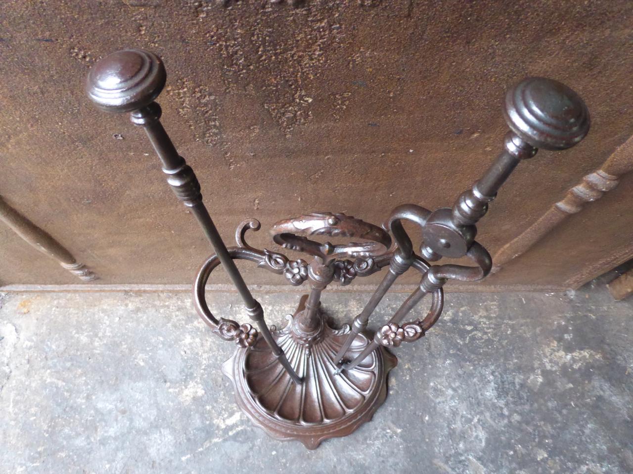 19th century English Victorian fireplace tool set. The fireplace companion set consists of a stand with two fireplace tools. It is made of cast iron and wrought iron. The fire irons are in a good condition and are fully functional.

We have a unique