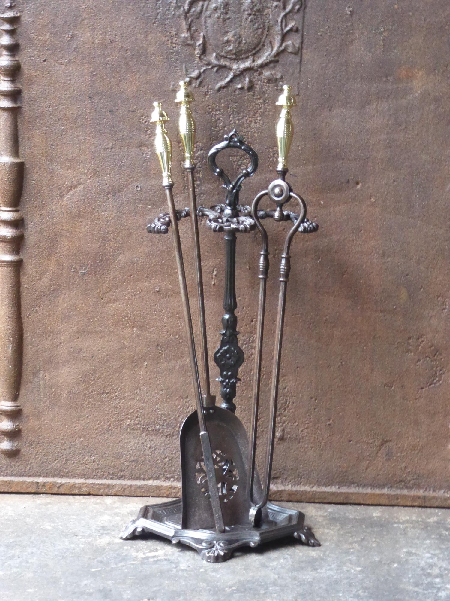 19th century English Victorian fireplace tool set. The companion set of fire irons is made of cast iron, wrought iron and polished brass. It is in a good condition and is fully functional.