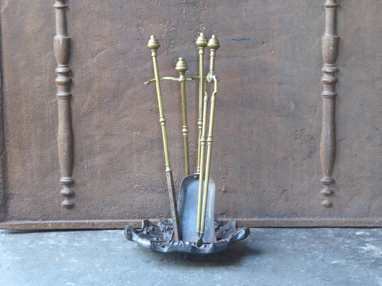 An elegant set of three brass fire tools and stand with ring-banded shafts. It is made of cast iron, wrought iron and brass. It is in a good condition and is fully functional.


