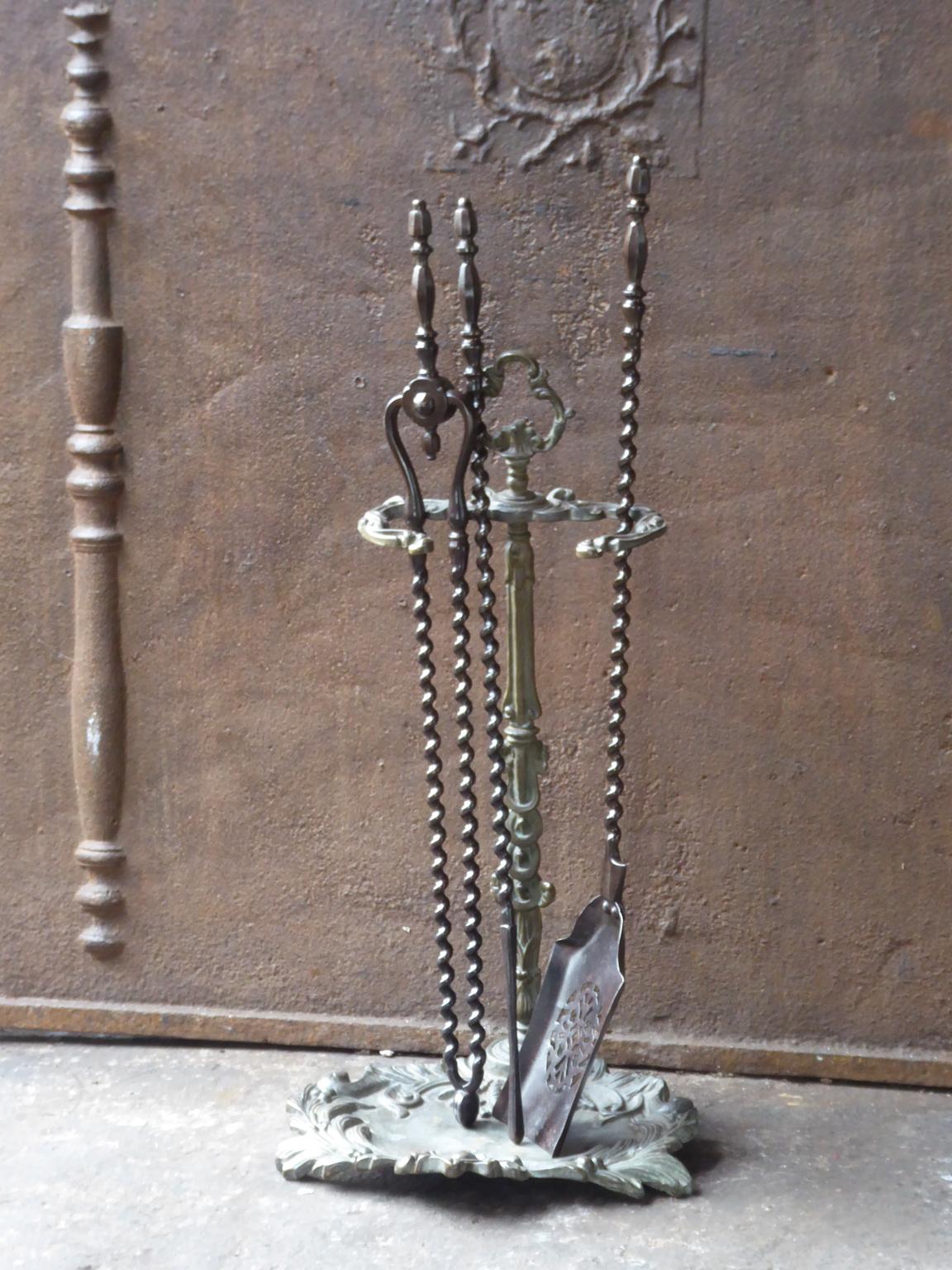 19th century English Victorian fireplace toolset made of brass and wrought iron. The toolset consists of three tools and a stand. The condition is good.













 