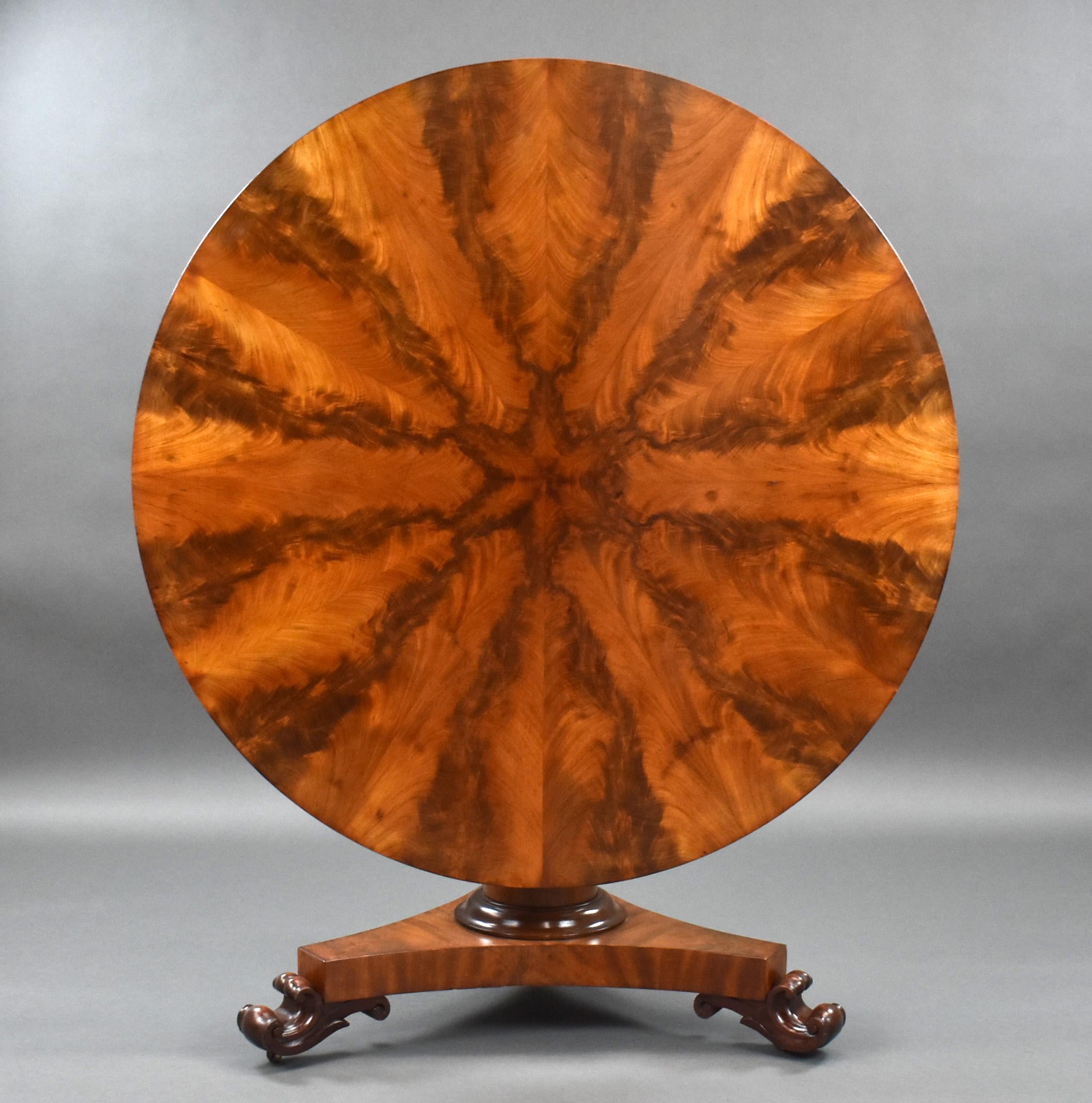 For sale is a good quality Victorian flame mahogany circular breakfast table. The top having superbly matched radial flame mahogany veneers, above a central column terminating on a platform base. The table stands on elegantly carved feet raised on