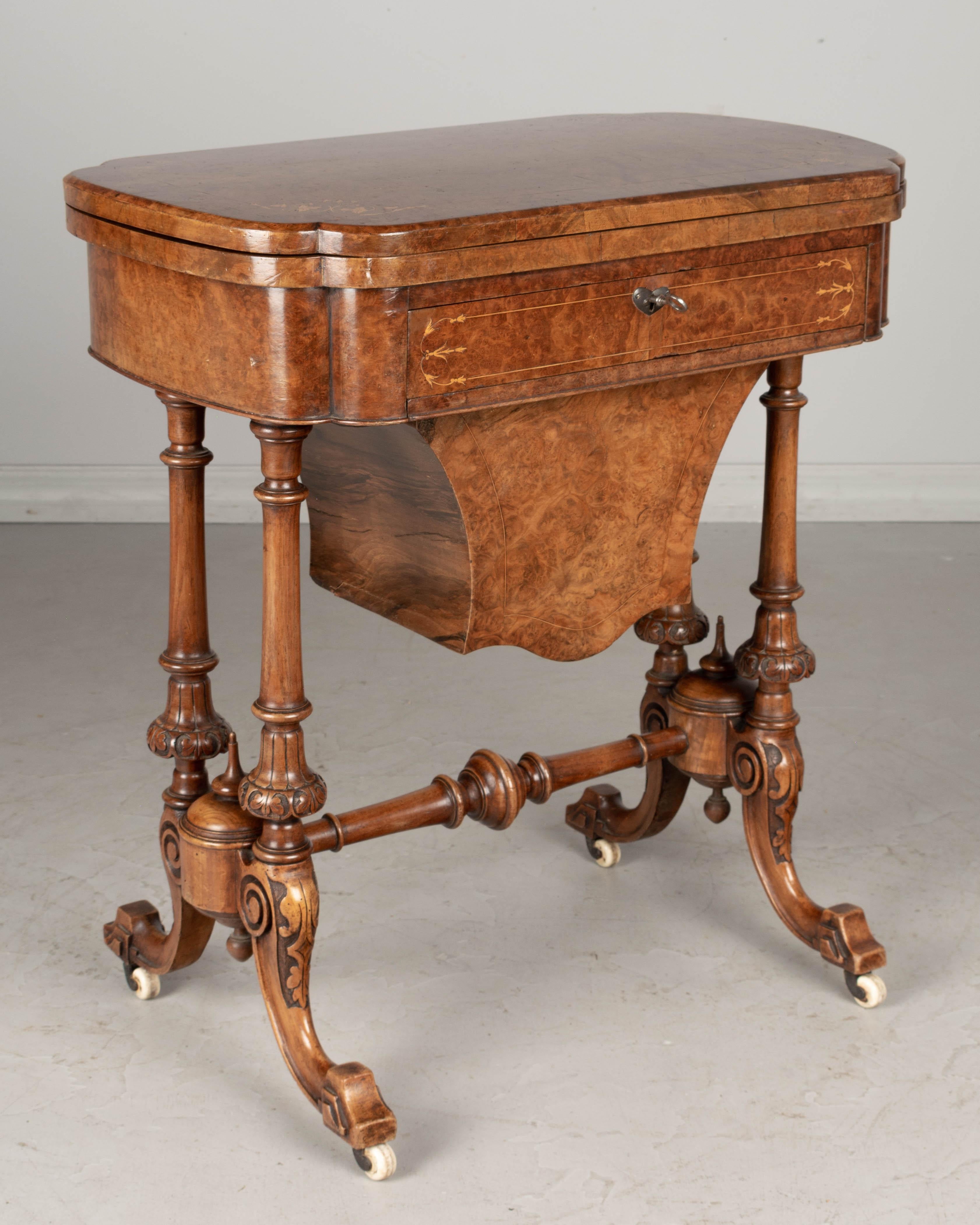 A fine quality 19th century English Victorian game table made of inlaid veneer of maple and solid mahogany. The swivel flip top hinges opens to reveal three inlaid game playing surfaces: backgammon, cribbage and chess boards. Dovetailed frieze