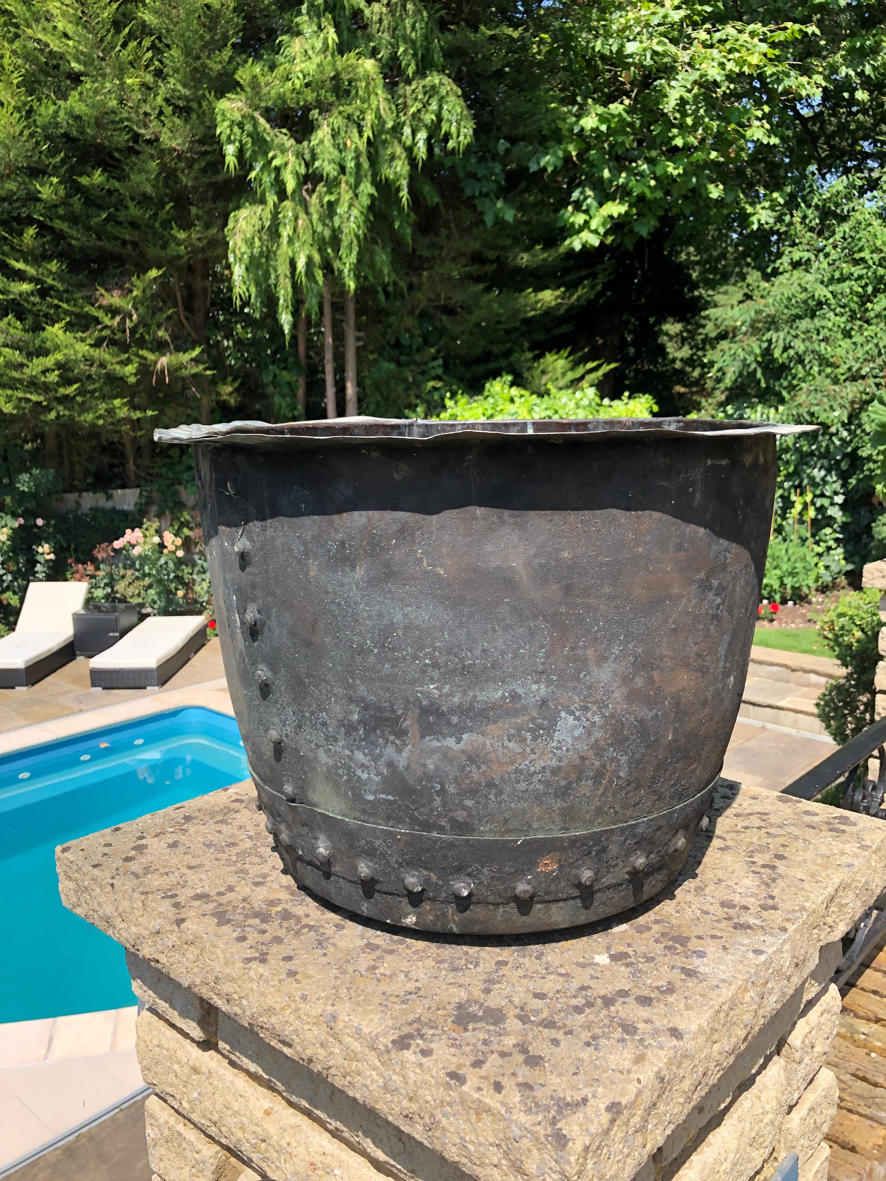 An English Victorian large riveted copper planter, originally used for boiling water for washing/laundry. It has an excellent patina and no dents or holes, with bolt rivets to side and base. These make excellent planters or log bins. Originally