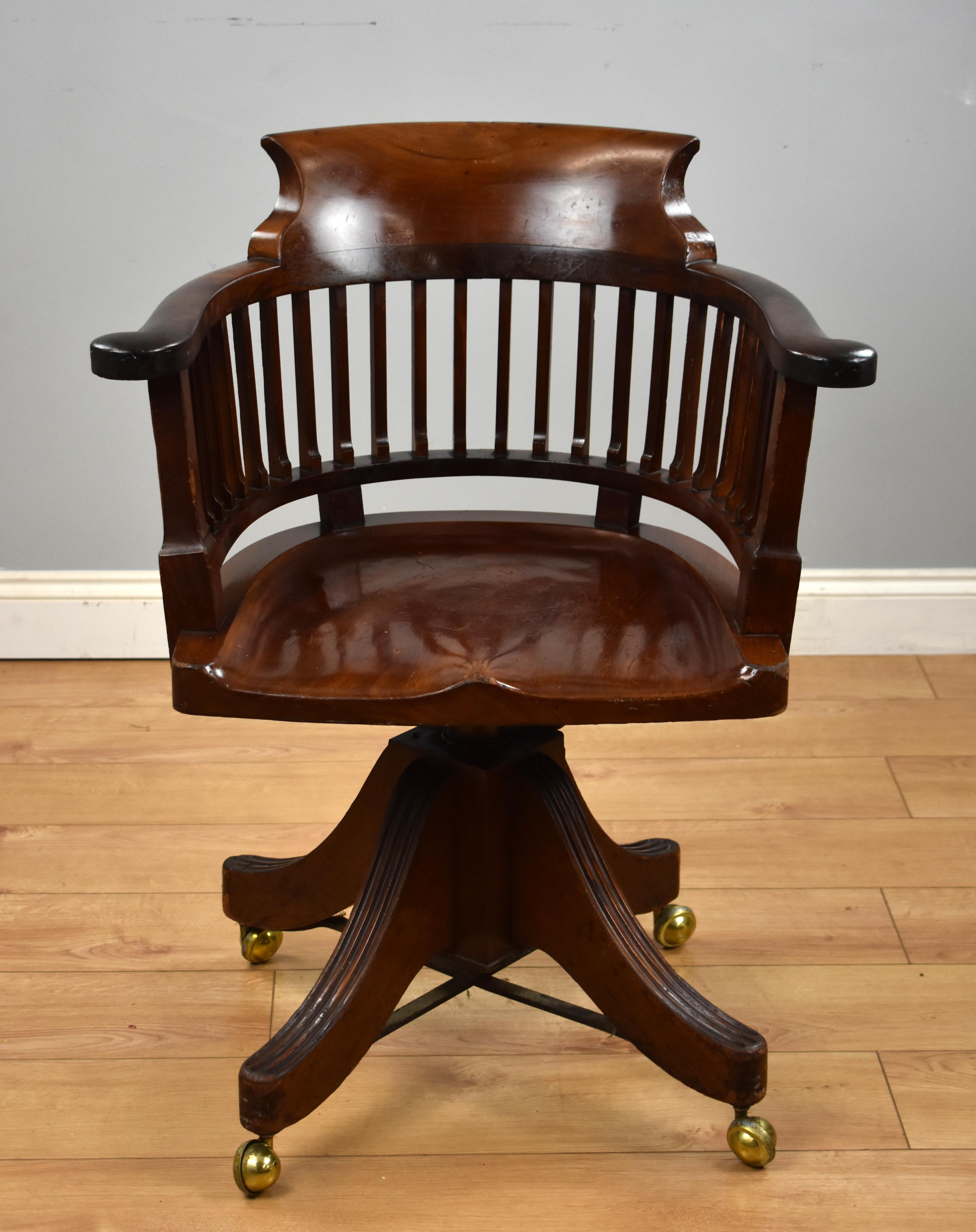 A Victorian mahogany desk chair, with bowed top rail, out swept arms above a solid shaped seat raised on an adjustable column with four down swept legs terminating on castors. This chair is in good condition with minor wear commensurate with age and