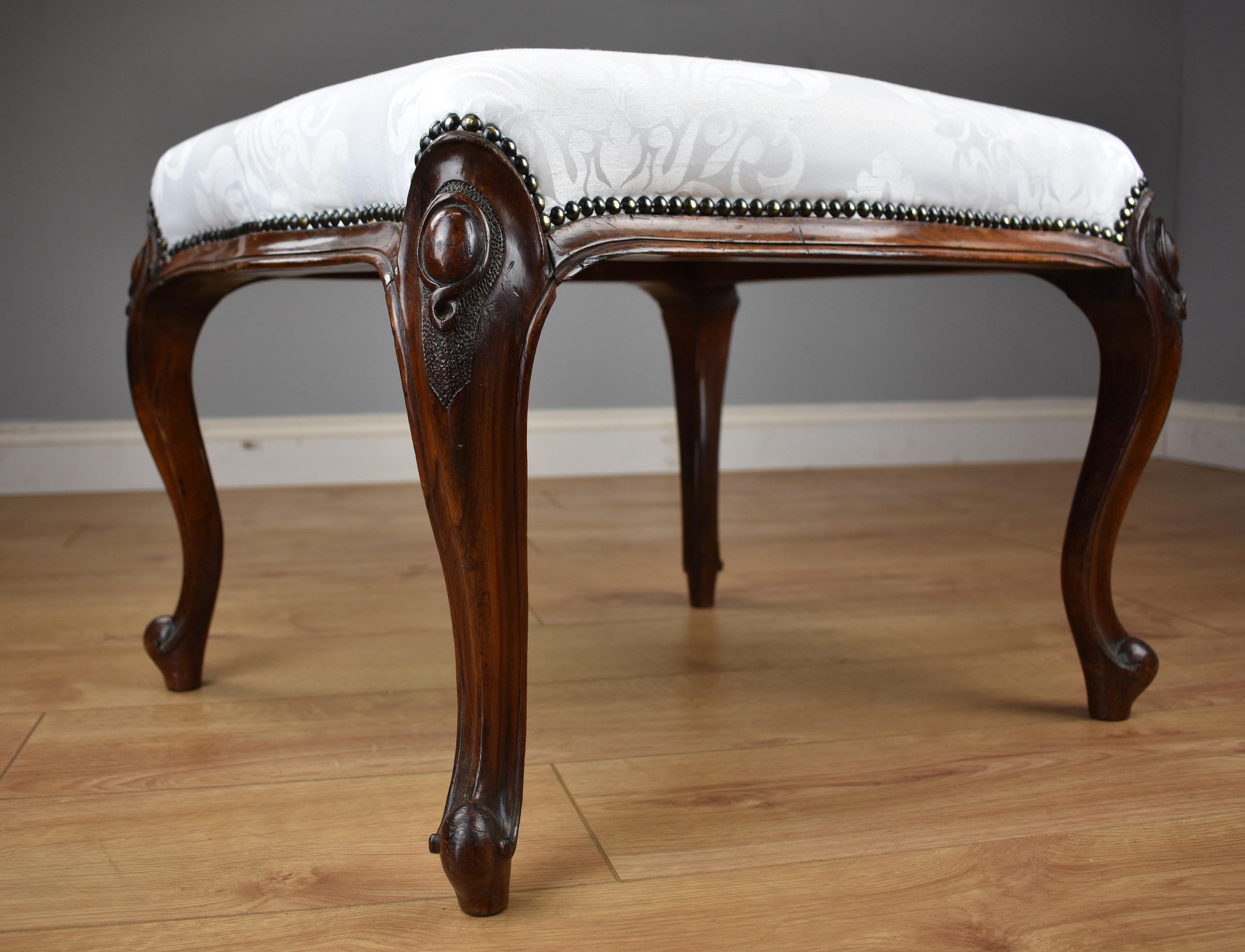 For sale is a good quality Victorian Mahogany foot stool, being serpentine in form, upholstered in floral damask faux silk, standing on elegant carved cabriole legs. This piece is in excellent condition for its age.

Width: 23
