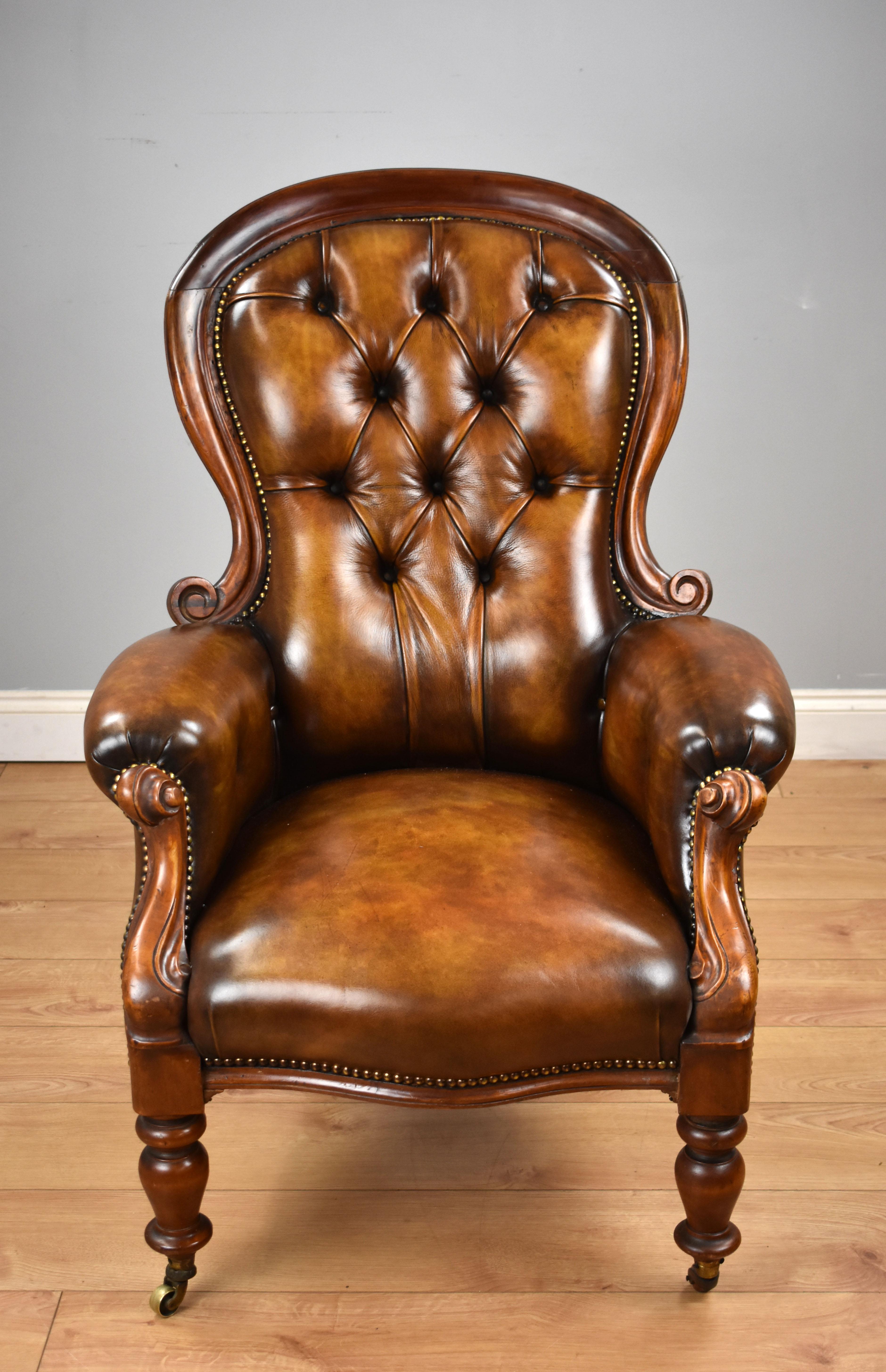 For sale is a good quality Victorian mahogany spoon back armchair, upholstered in quality leather hide and hand coloured to a high quality finish, the chair has a deep buttoned back and a carved frame, standing on turned legs terminating on castors.