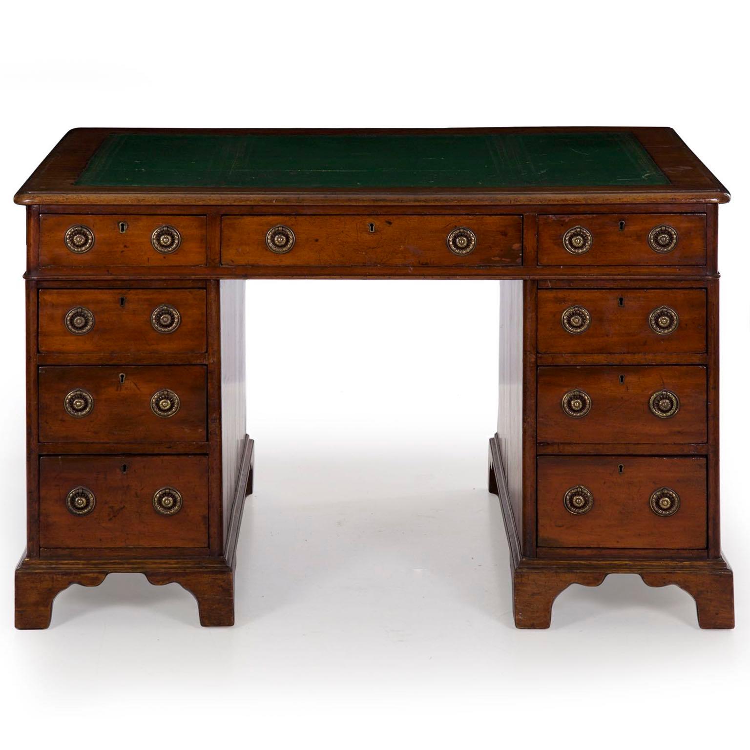 An attractive and well worn English Victorian period antique pedestal desk from the third quarter of the 19th century, the warm patina in the mellowed mahogany is most striking. The gilt tooled green leather top is quite old and likely original,