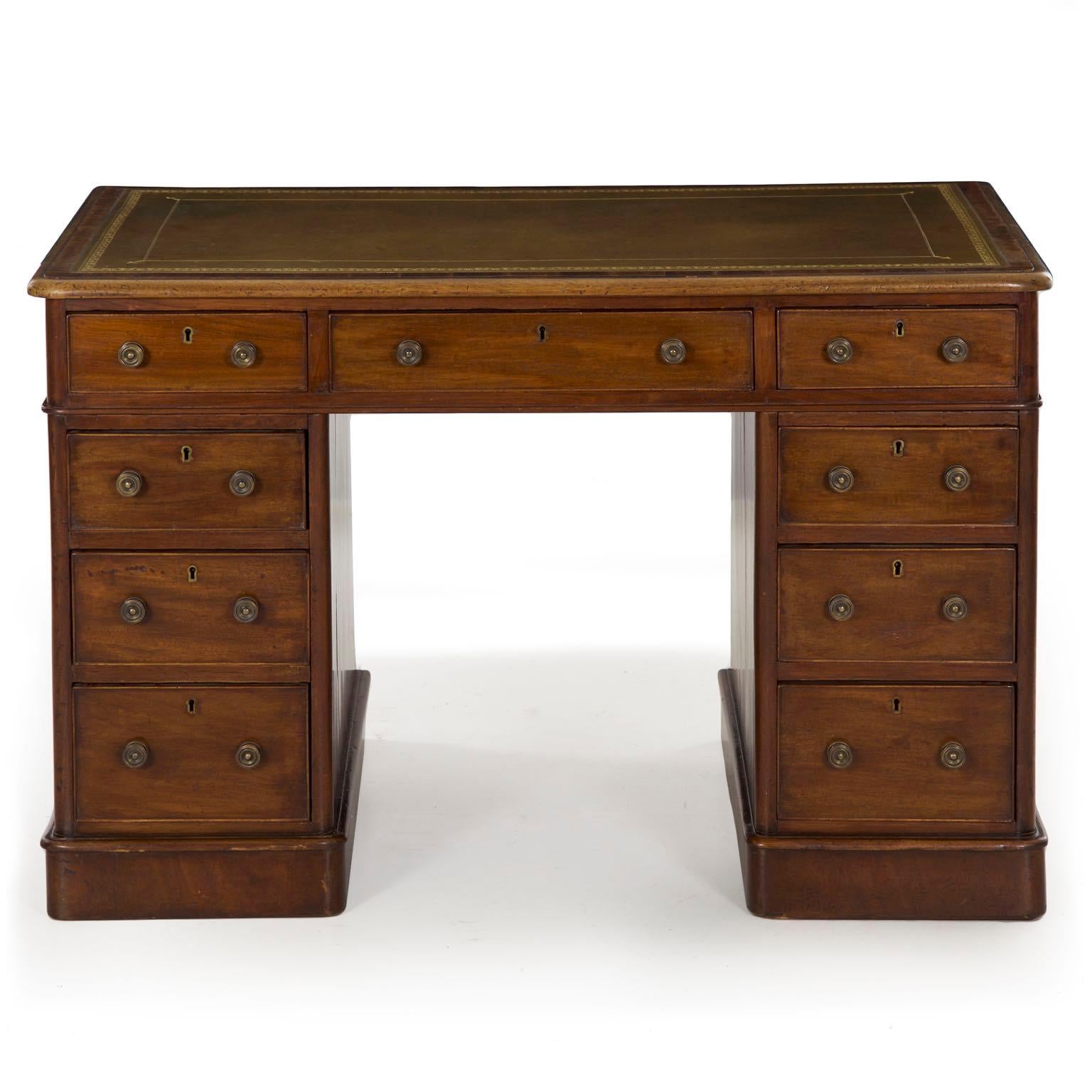 A very nice little writing desk of unusually restrained dimensions for a pedestal form, this product of the Victorian period is beautifully crafted with a mellow olive-green gilt-tooled leather top an attractive patinated mahogany primary surfaces.