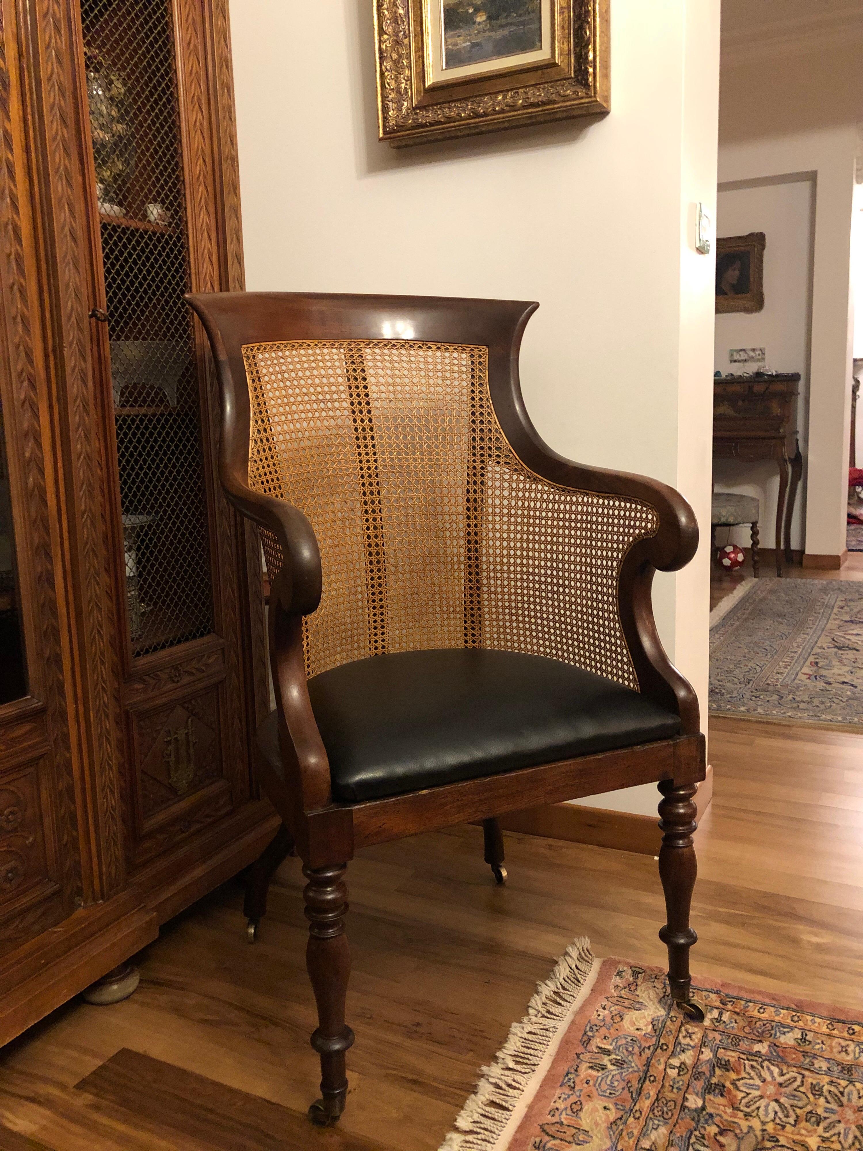 An early Victorian mahogany bergere armchair or library chair, with caned back and sides, with a drop-in seat with later leather upholstery, on baluster turned front legs and brass caps and castors. Excellent condition.
England, circa 1840.
 