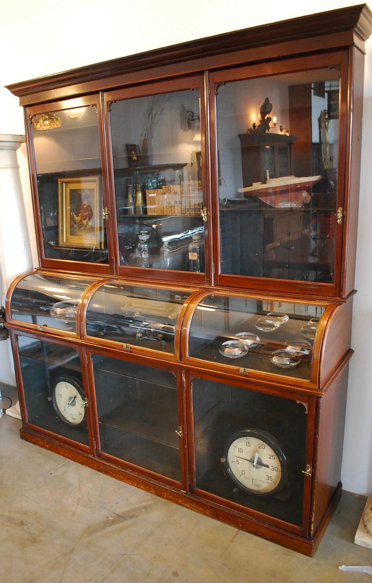 Victorian solid mahogany and brass mercantile shop display cabinet. This outstanding large cabinet has adjustable shelves, original finish, with a moulded cornice above three glass doors fitted with original brass knob handles and lock.
Centre