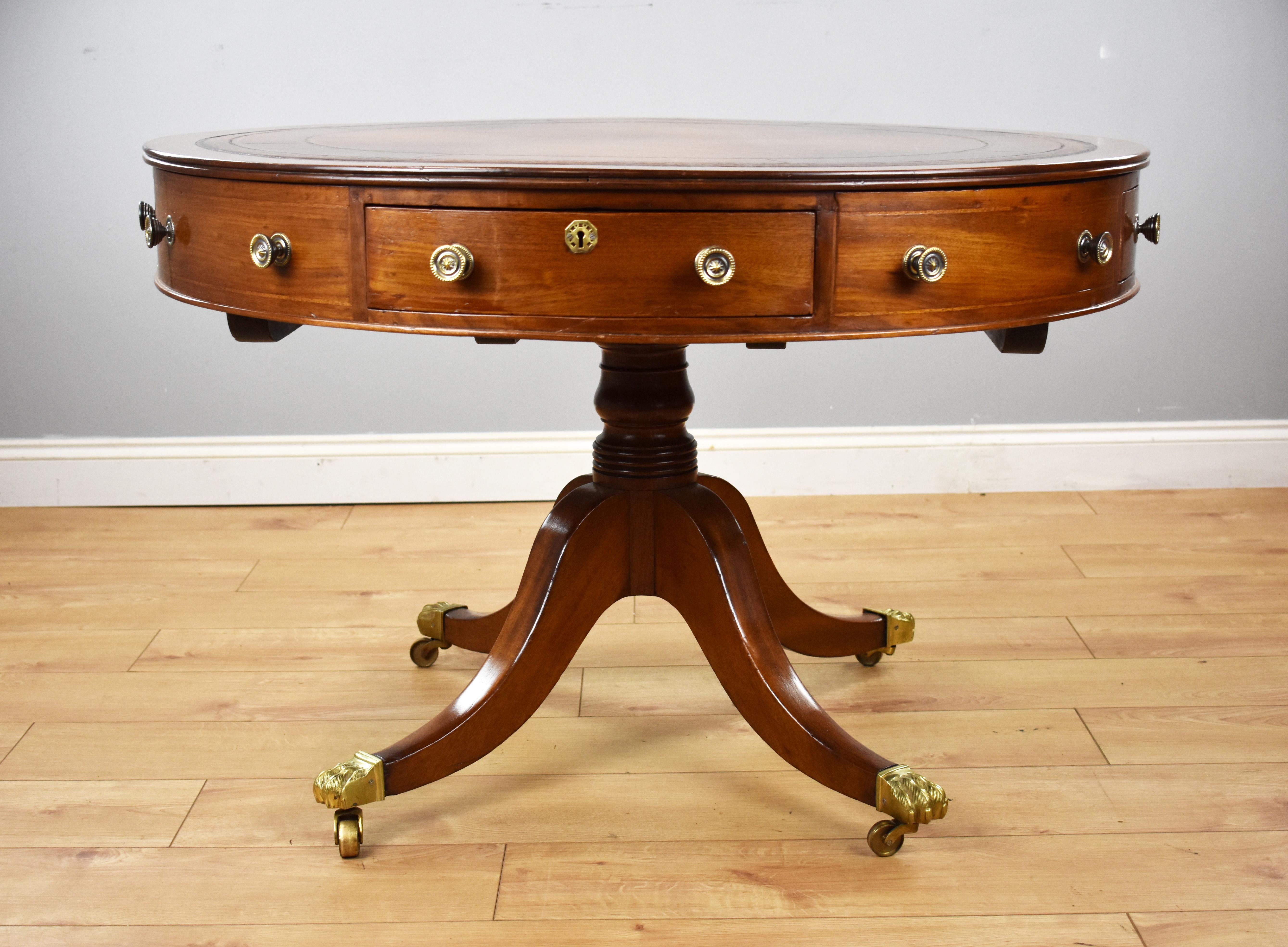 For sale is a Victorian mahogany rent table, fitted with a hand dyed leather hide top, decorated with gold and blind tooling, above two long drawers, two short drawers and four dummy drawers. The table stands on a turned base, raised on splayed legs