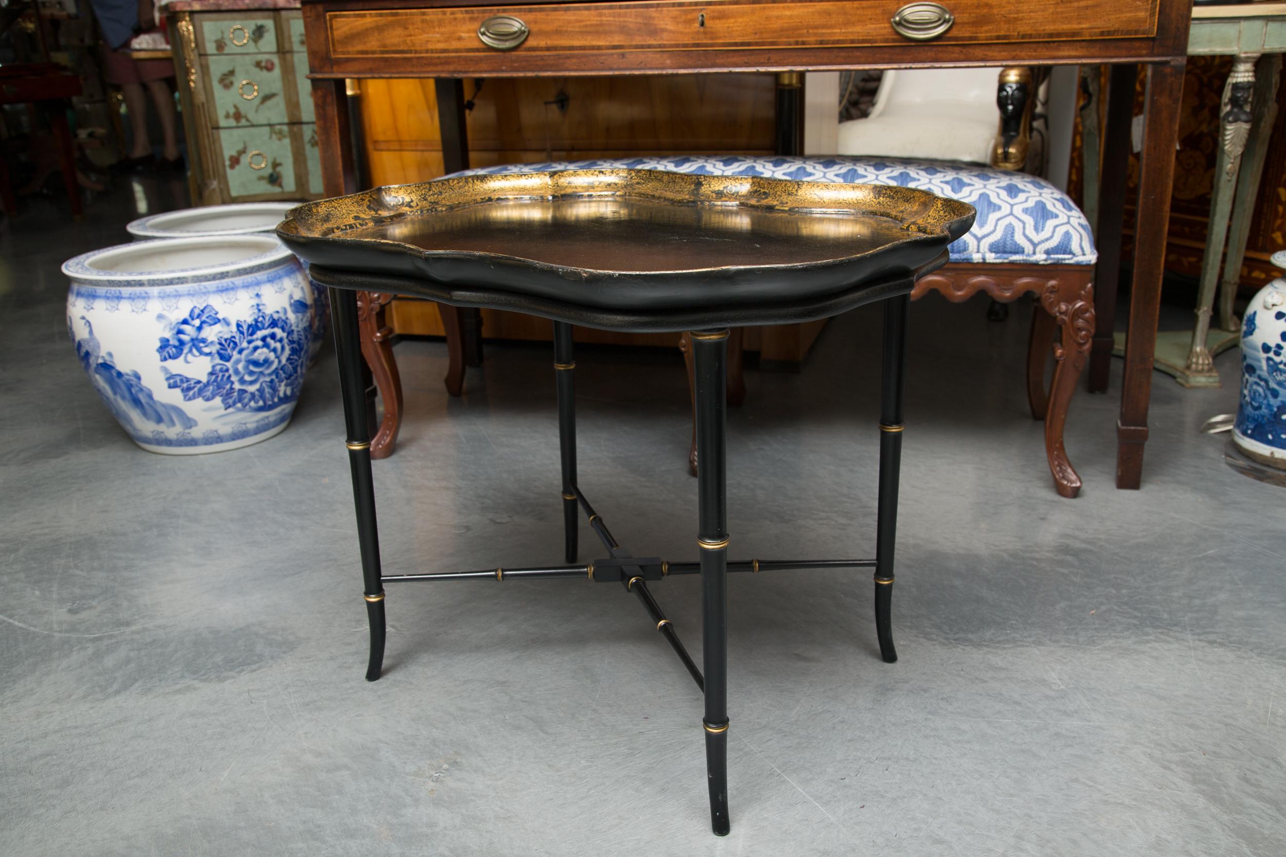 This is a Classic black English Victorian papier mâché tray with an interior gilt border. The tray is fitted to a latter ebonized faux bamboo stand, circa 1860 (tray).