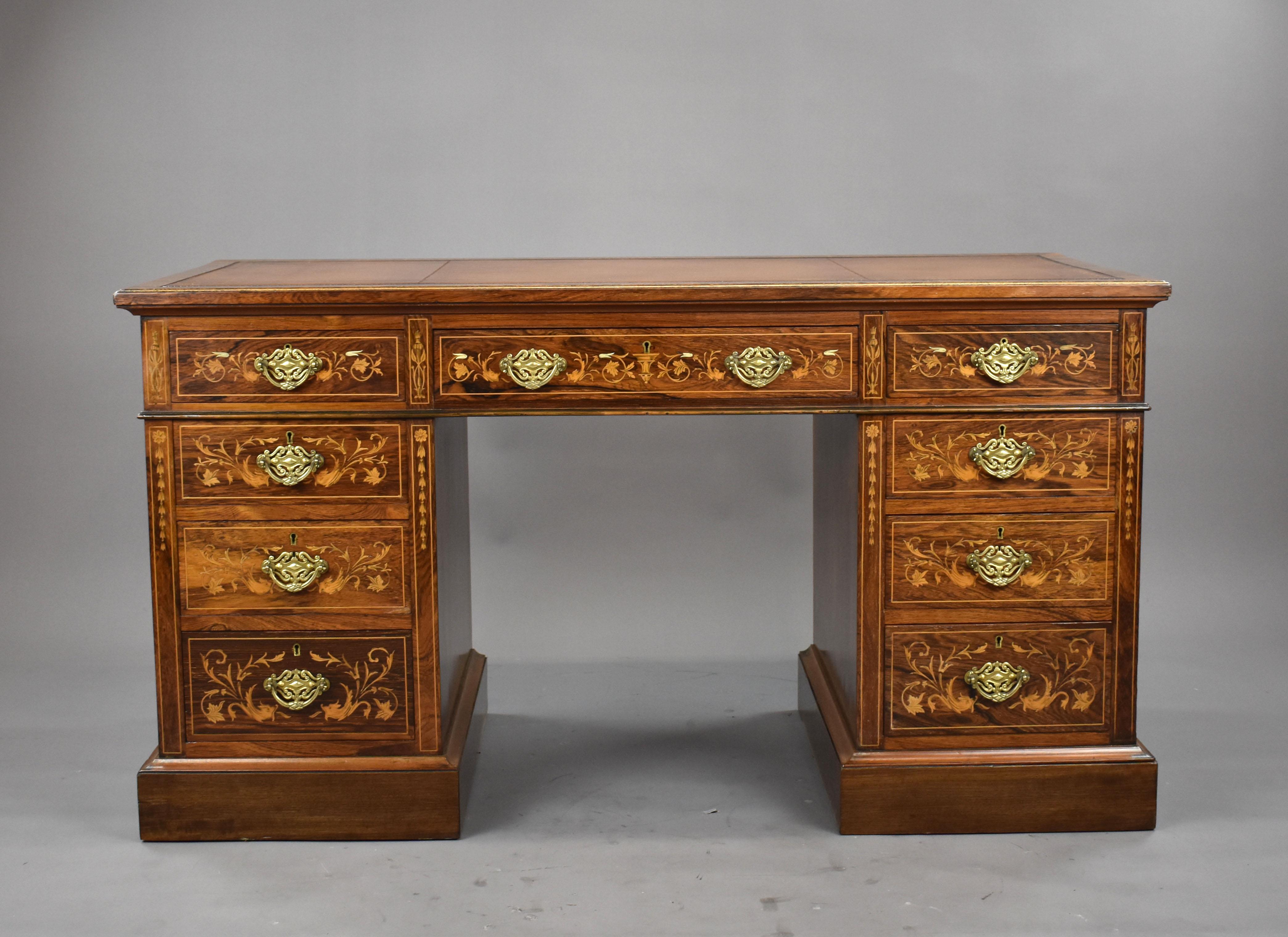 A good quality Victorian rosewood and marquetry writing, having a green leather writing surface, decorated with blind and gold tooling above an arrangement of 9 drawers, each with original brass handles. The desk stands on a plinth base and is in