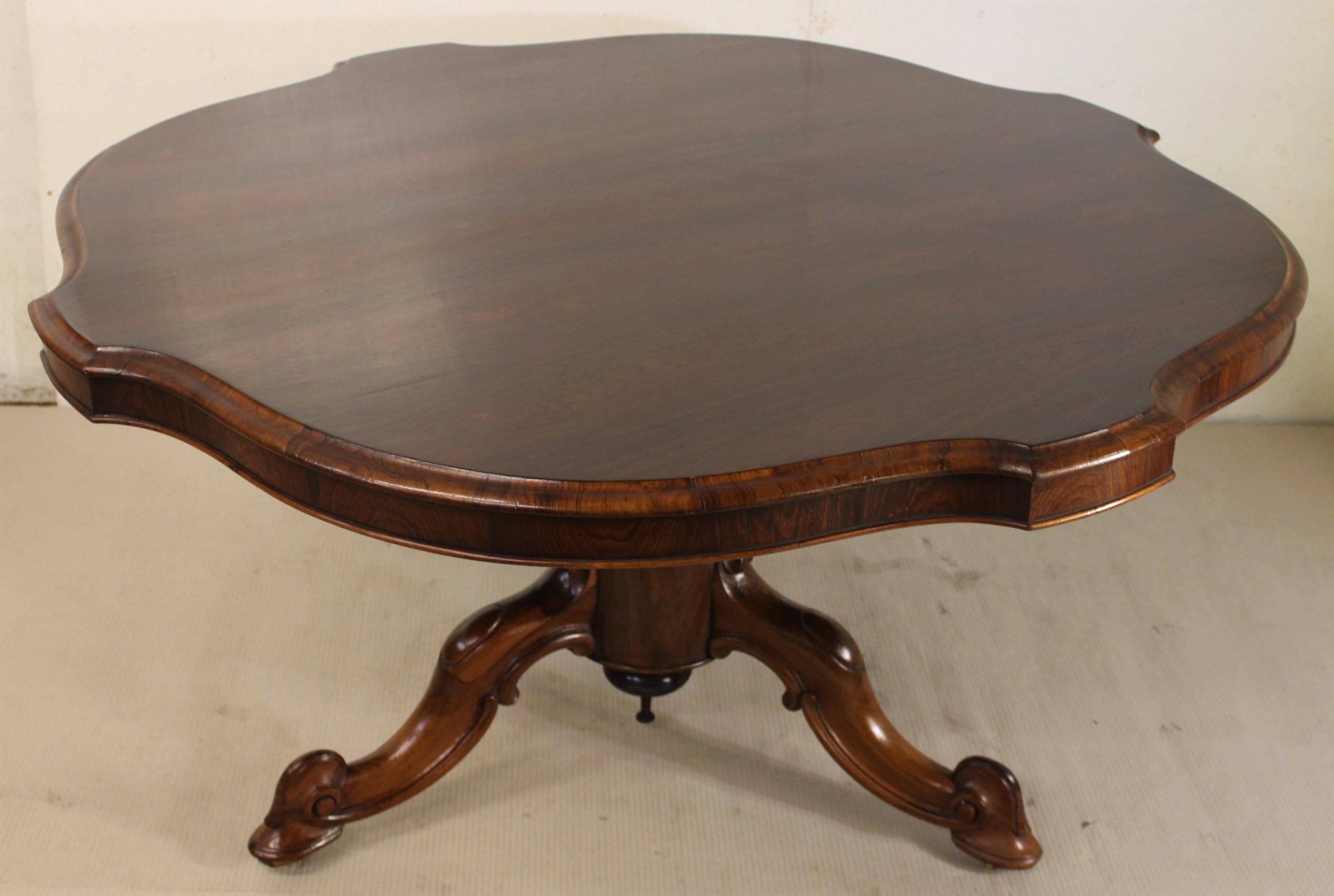 A fine quality Victorian period rosewood loo, or supper, table. Very well constructed in solid rosewood and attractive rosewood veneers onto a mahogany frame. The shaped top can be tilted up when not in use. The top is supported by a single central