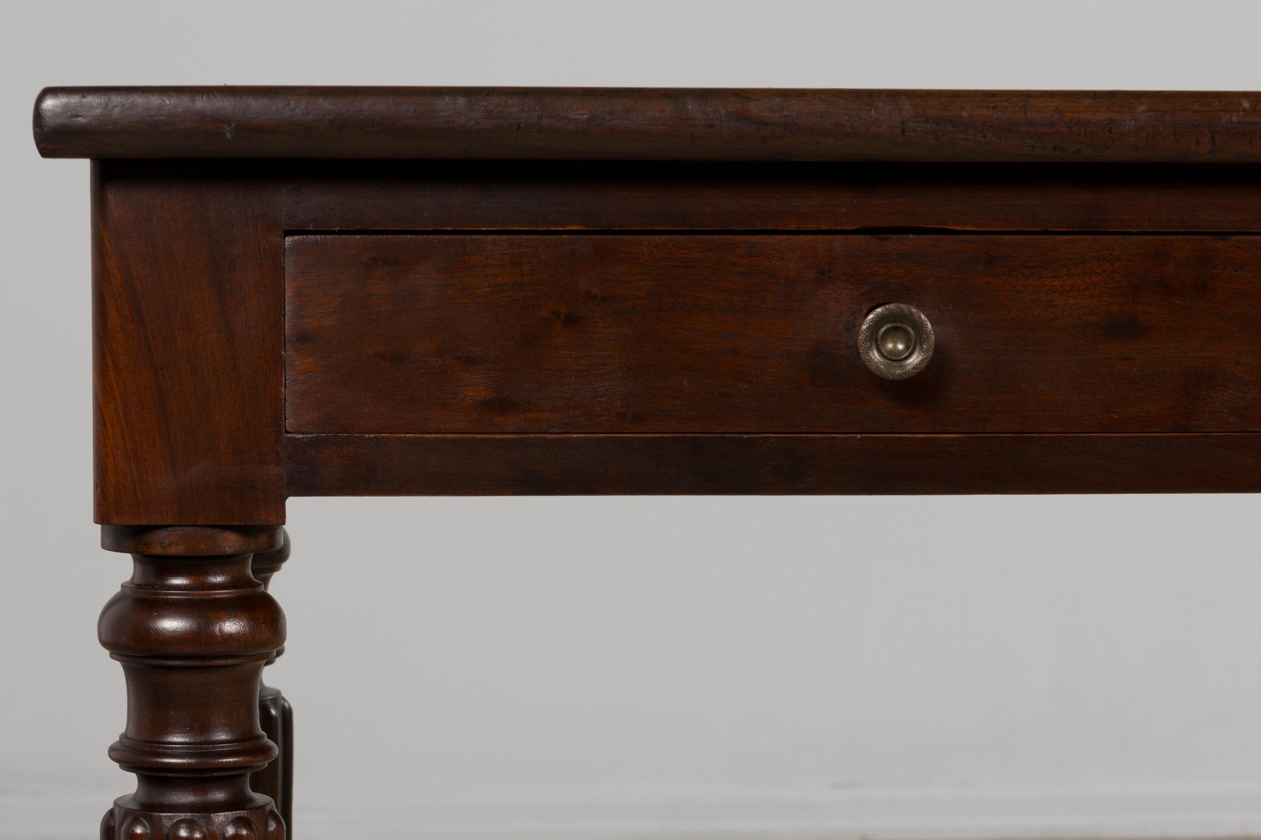 Elegante consola de finales del siglo XIX, de estilo victoriano, procedente de Provenza (Francia). Fabricada a mano por expertos en caoba maciza, la pieza presenta un marco rectangular largo y estrecho y una parte superior de piel de vaca italiana