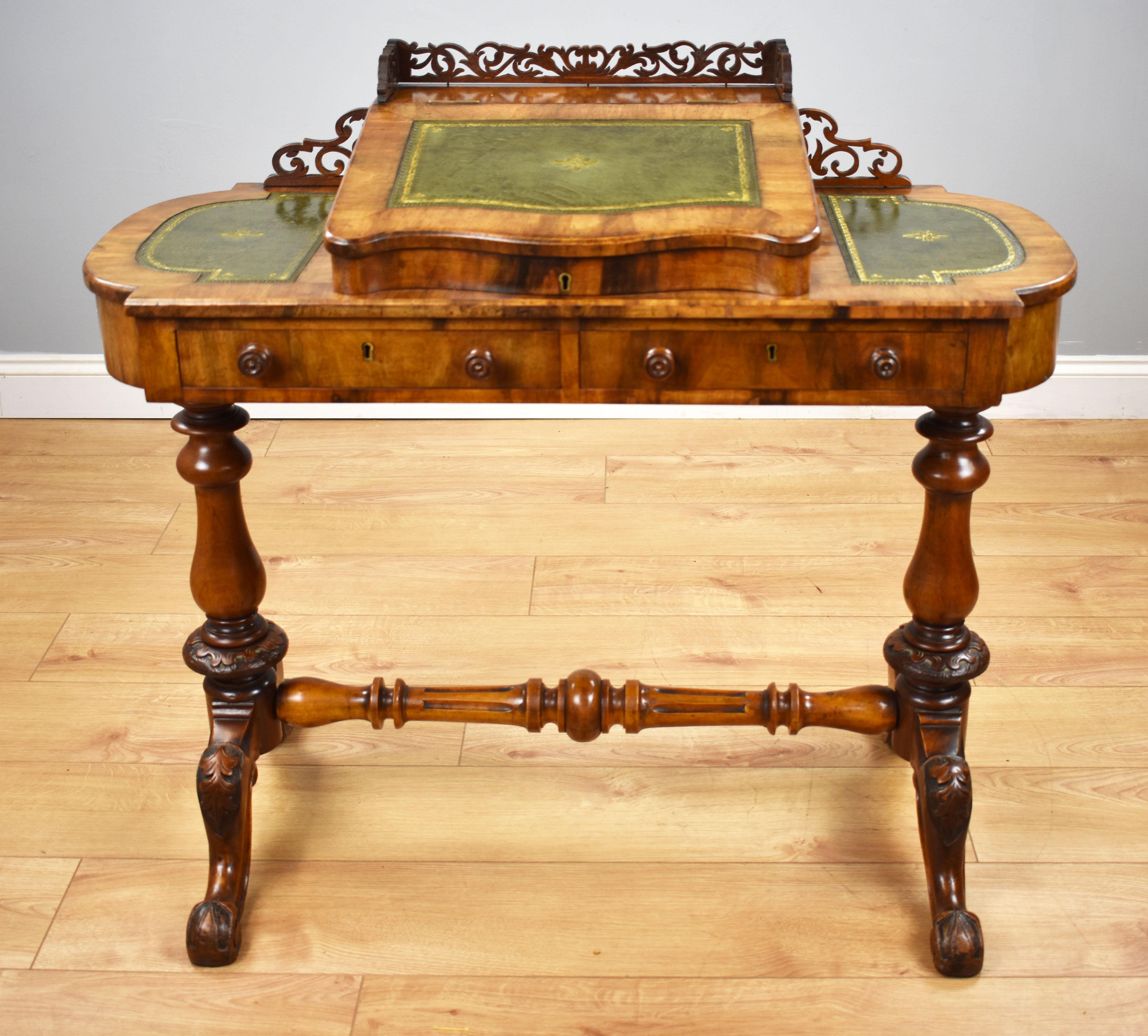 For sale is a Victorian walnut writing table, with an ornate fretwork gallery, above a sloped and rising writing surface inset with a green leather skiver, rising to reveal storage space. This is flanked by two more leather inserts, all with