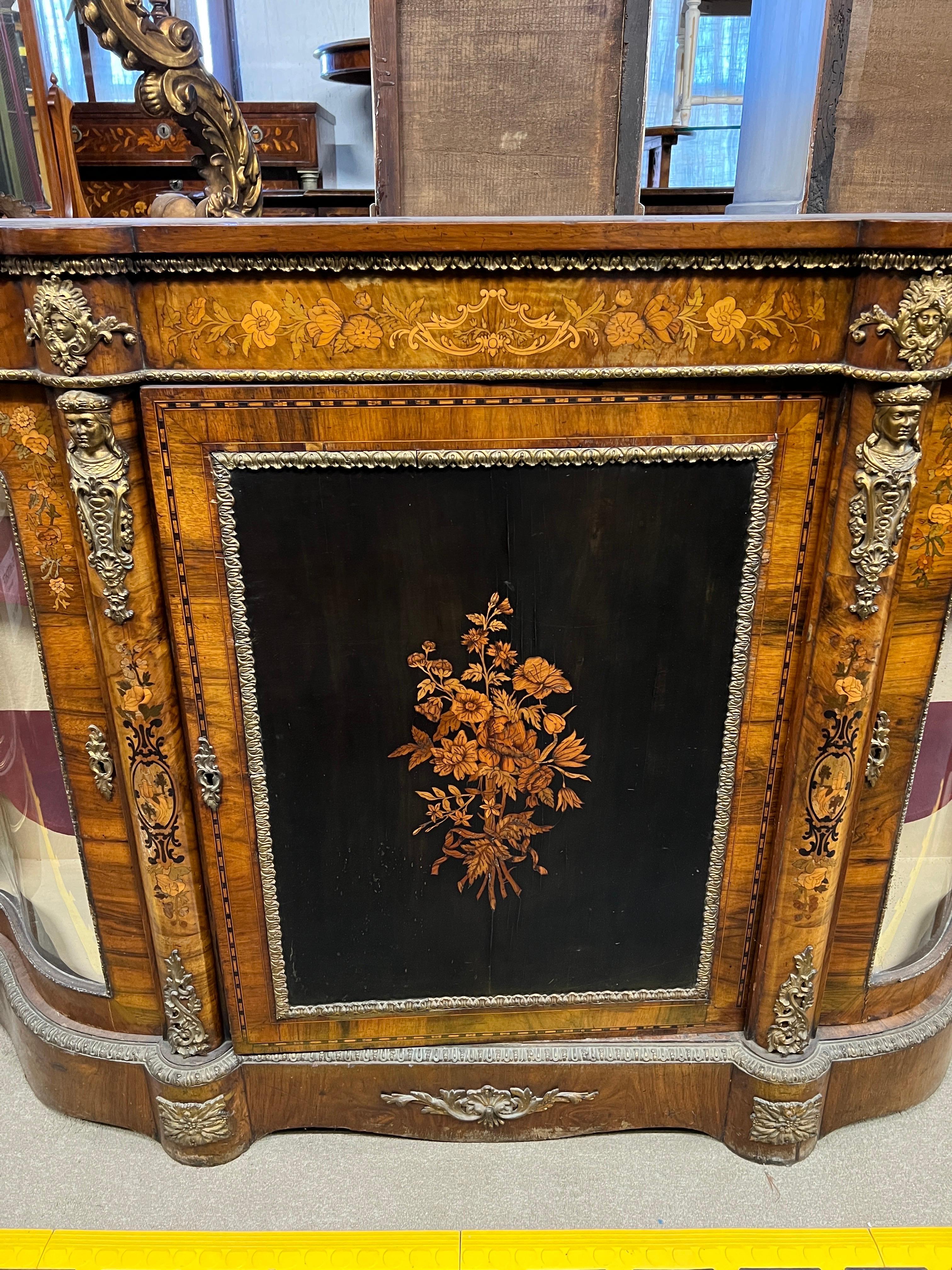 Fantastic serpentine Moved Sideboards, made of walnut burl, with fruitwood inlays , bronze applications depicting faces of women and men, floral pattern inlays and on the uprights landscape with castle.
Furniture that looks like small works of art,
