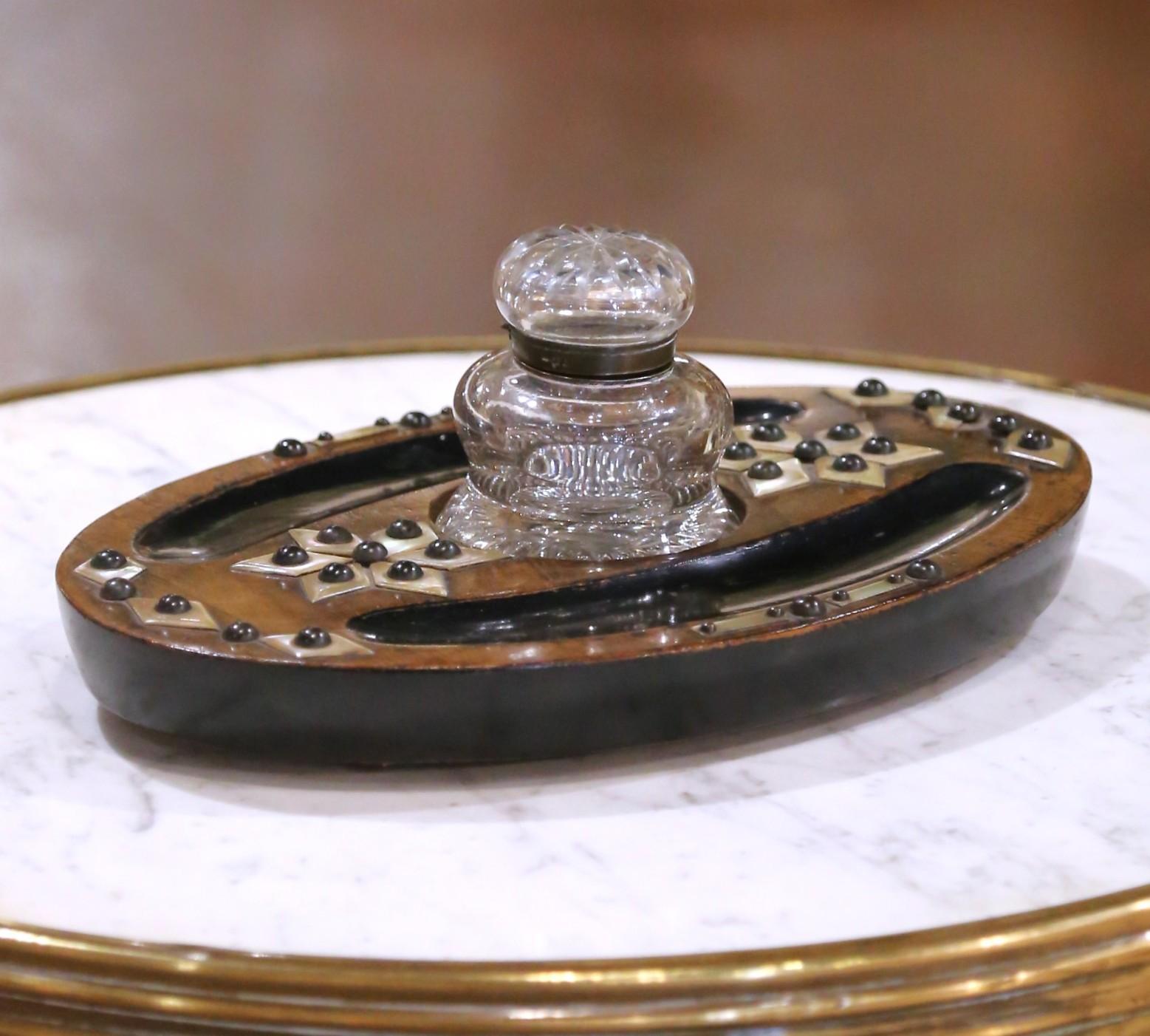 Aggiungi un tocco di eleganza ottocentesca alla tua scrivania con questo calamaio Victorian Aesthetic Movement, realizzato in Inghilterra intorno al 1870. La base ovale è realizzata in caldo legno di noce e presenta due vassoi portapenne incassati,