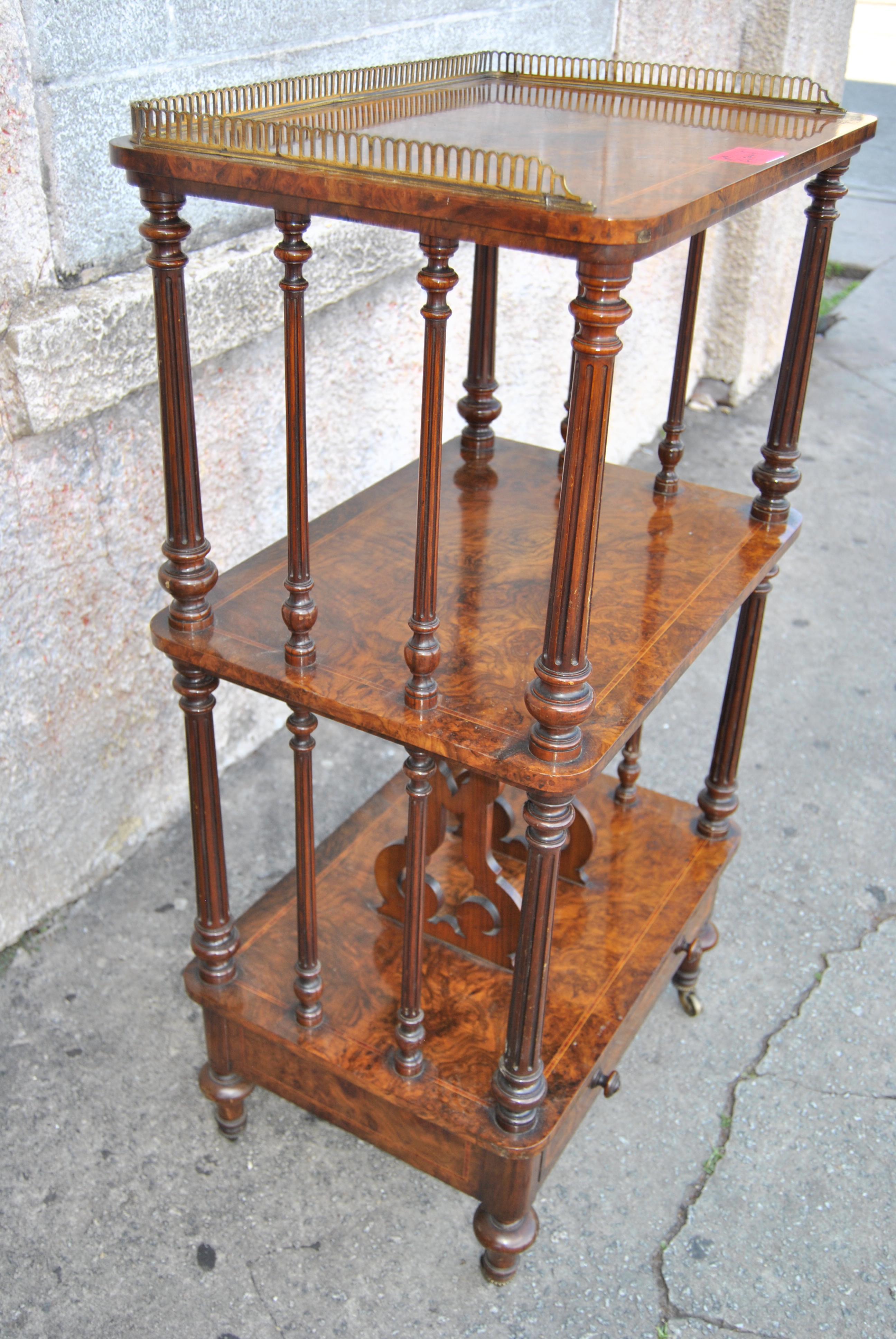 This is a Canterbury or bookcase or 3-stage display or server made in England, circa 1870. The piece is made of Kashmir walnut (the finest cut of Burr Walnut). There is a pierced brass gallery on the right and left sides and across the back of the