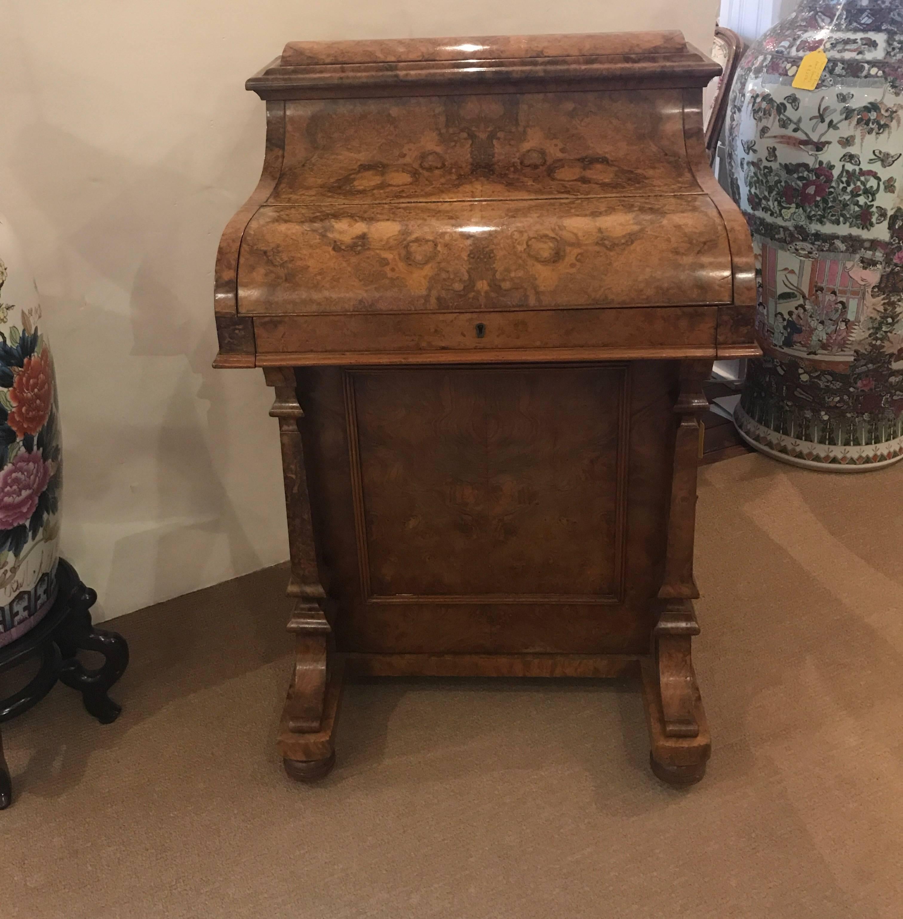 Exceptional quality English Davenport desk in burl walnut. The smokey burl grain with recent French polish. The desk has many drawers and compartments and a flip front to Revel and original dark green leather writing surface. The top with a spring