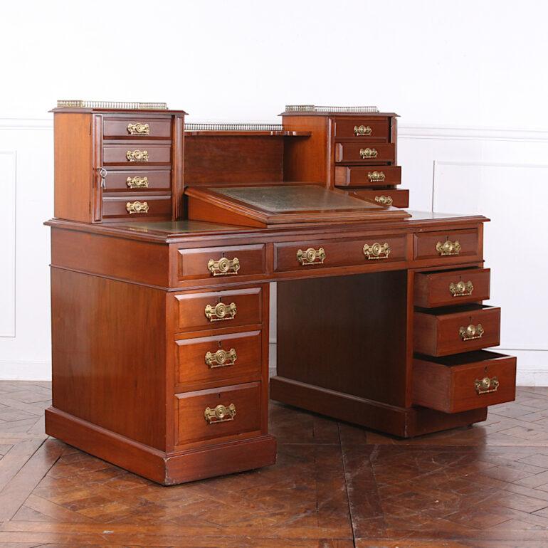 An impressive English Victorian walnut ‘Dickens’ desk, so-called because a desk of similar design used by Charles Dickens. The desk features two banks of graduated drawers on each side of the knee hole, and an upper centre drawer. Slanted leather