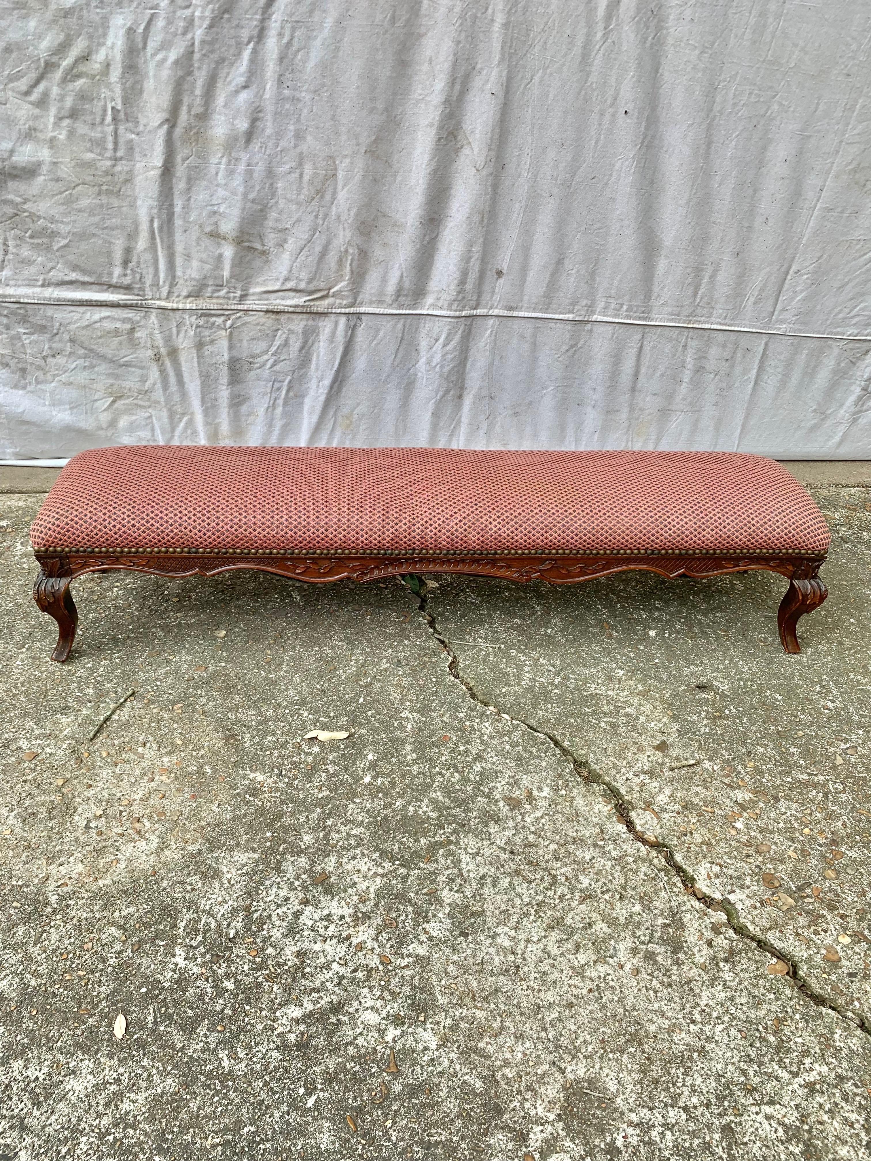 Ce banc ou repose-pieds anglais du XIXe siècle a été fabriqué à la fin des années 1800 en noyer ancien. La pièce présente un plateau rembourré, tel qu'il a été trouvé, fixé par des clous en laiton, reposant sur une base allongée sculptée à la main