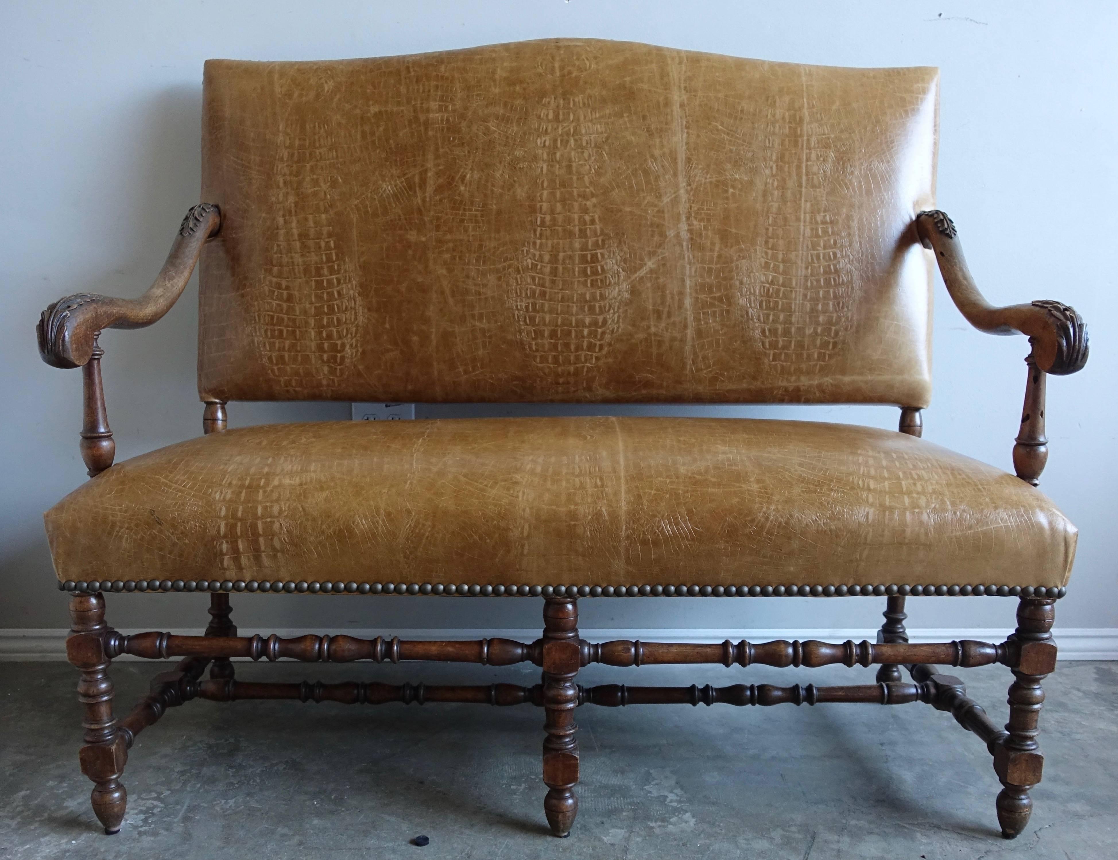19th century English walnut embossed leather bench with nailhead trim detail. The bench stands on six turned legs connected by a bottom stretcher.