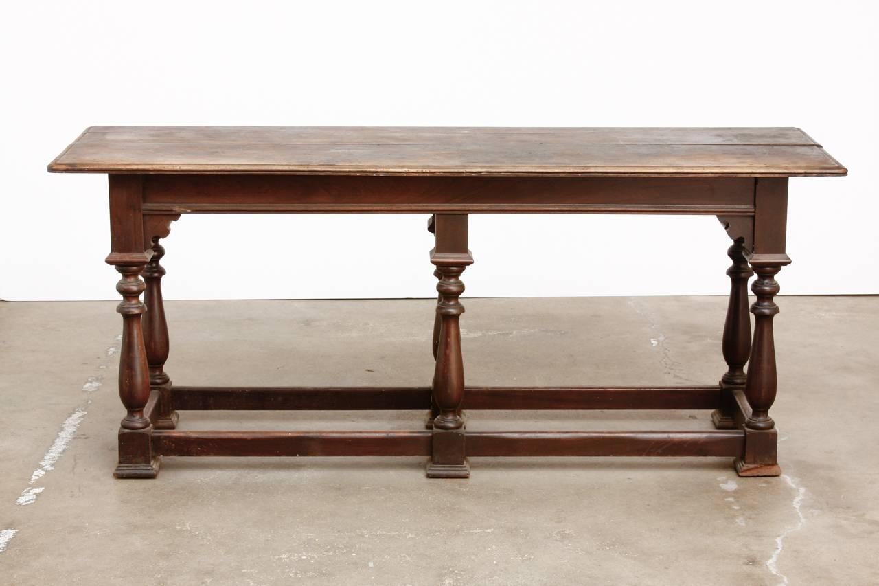 Rustic 19th century English walnut refectory table or console table. Features a plank top made in the William and Mary taste. Supported by six baluster form legs conjoined with a box stretcher. Originally produced as a refectory or serving table