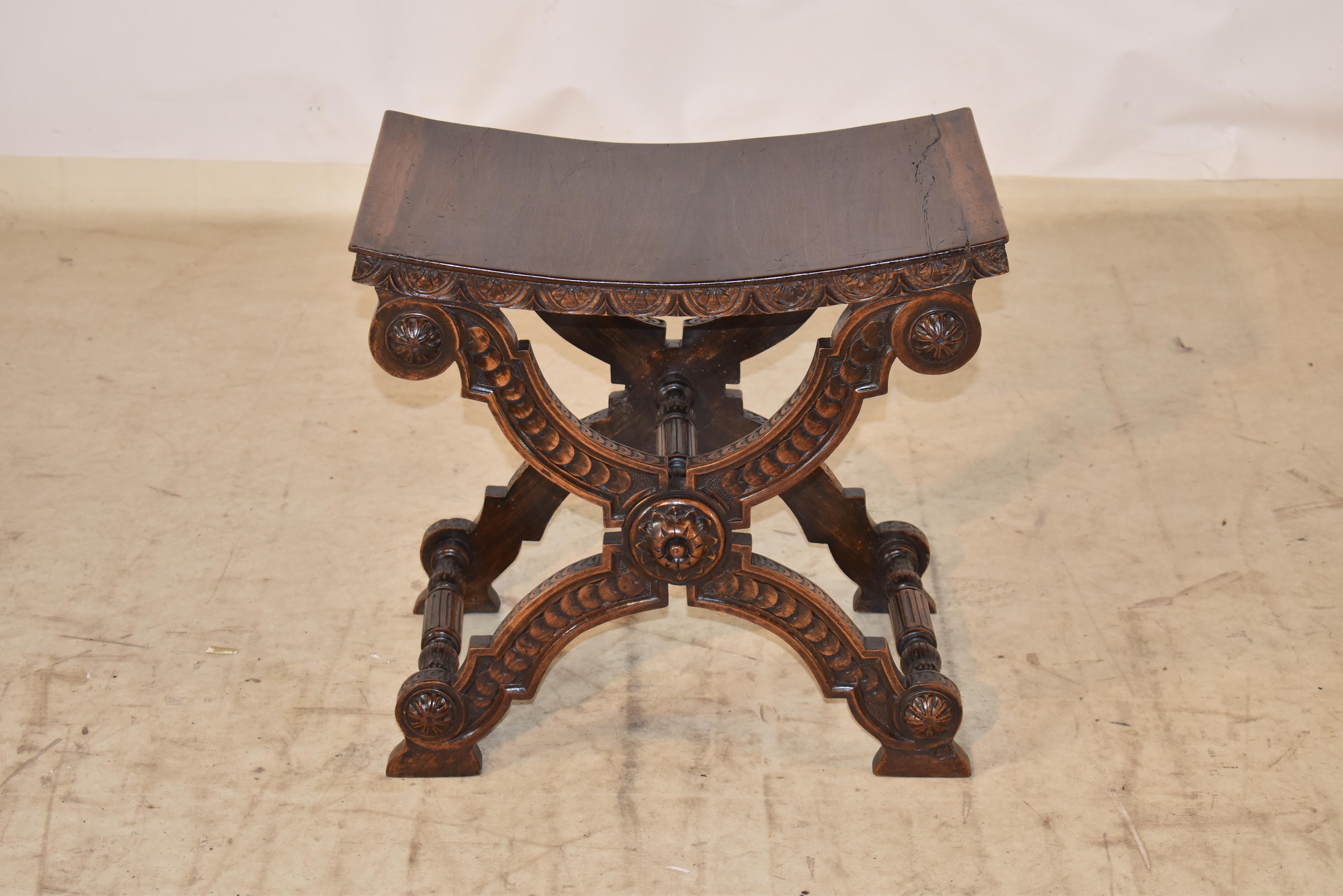 Tabouret Savonarola en noyer anglais du 19e siècle, magnifiquement sculpté à la main.  L'assise est incurvée et descend jusqu'à un tablier sculpté à la main.  Le tabouret repose sur des pieds décorés merveilleusement façonnés et sculptés à la main. 