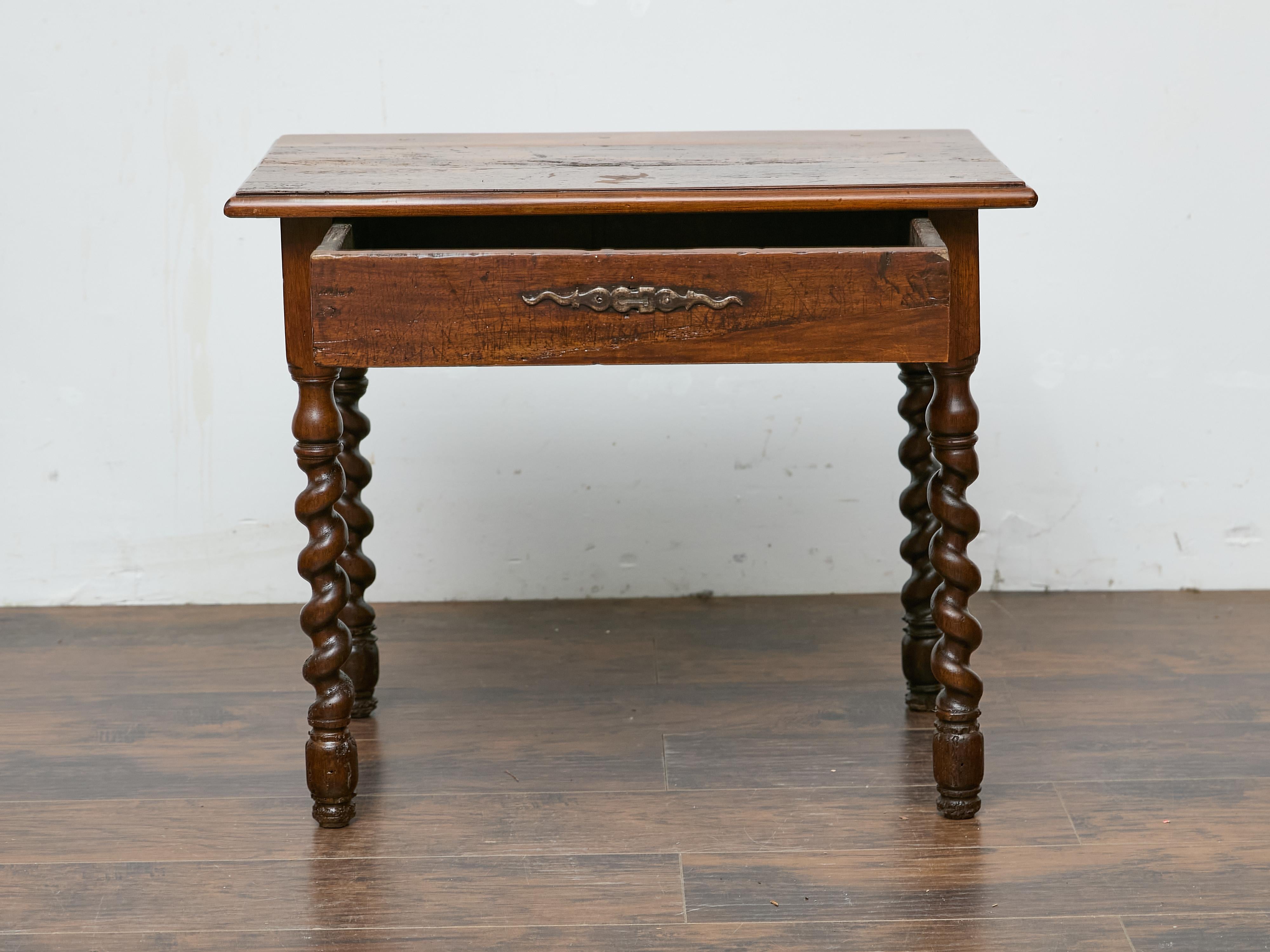 Cette table en noyer du XIXe siècle, qui s'appuie sur l'artisanat anglais, présente un caractère distinctif avec ses pieds torsadés en orge et sa patine bien usée. La finition riche et adoucie par le temps met en valeur le mouvement organique du