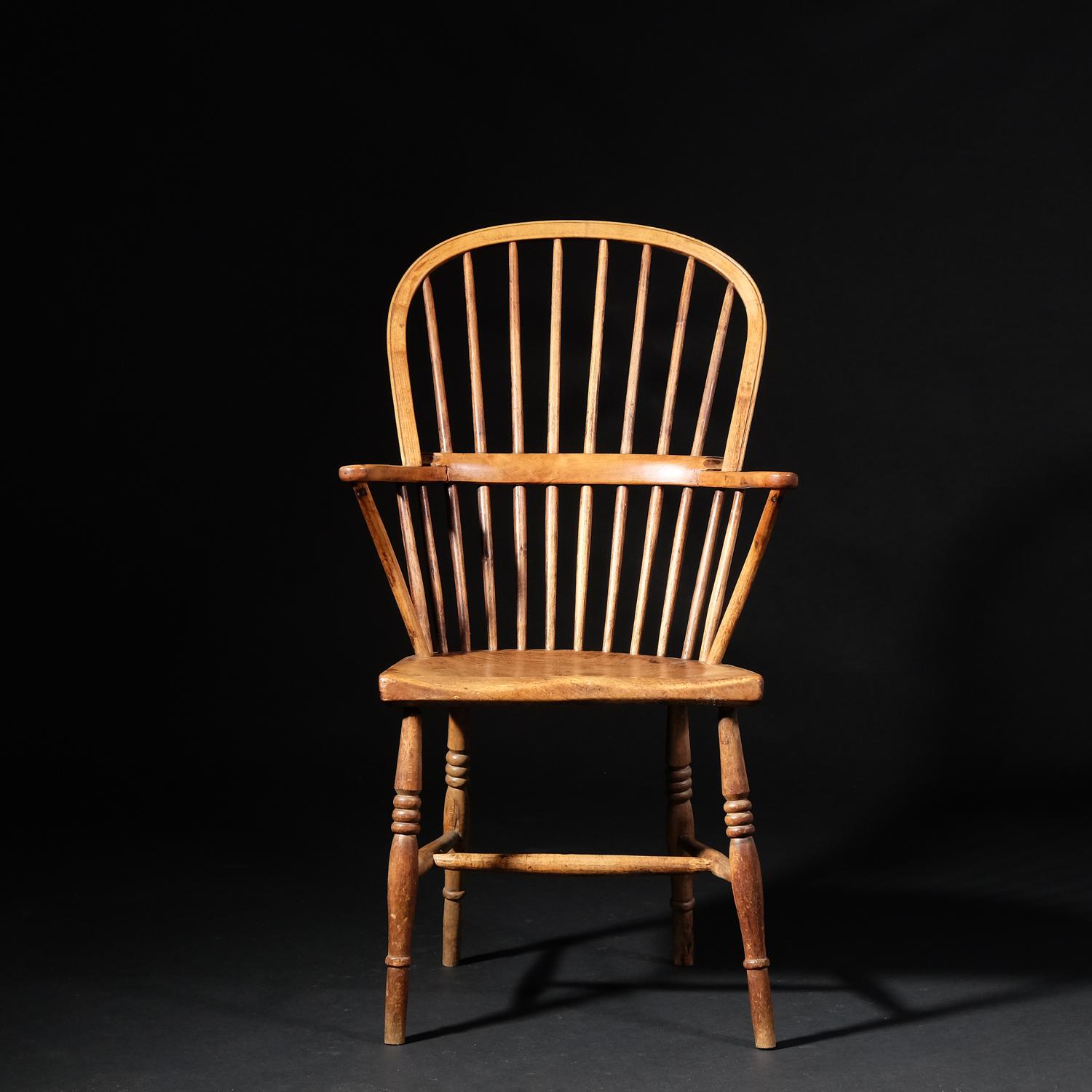 A good stick back Windsor armchair in yew, elm and ash. Ring turned legs, united by an H-stretcher, a nicely figured elm slab seat with subtle saddle shape, crooked arm supports with a three-part yew arm and a simple hoop and stick back. Solid,