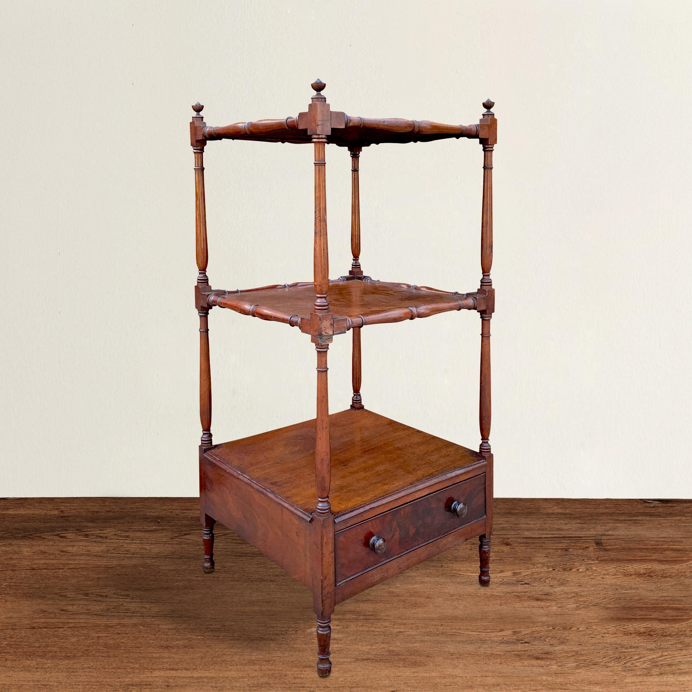 A fantastic 19th century English mahogany whatnot, or tired stand, with beautifully turned supports mimicking columns, with turned frames supporting solid mahogany shelves, and a lower drawer with a crotch mahogany front and two knobs. Shelf is