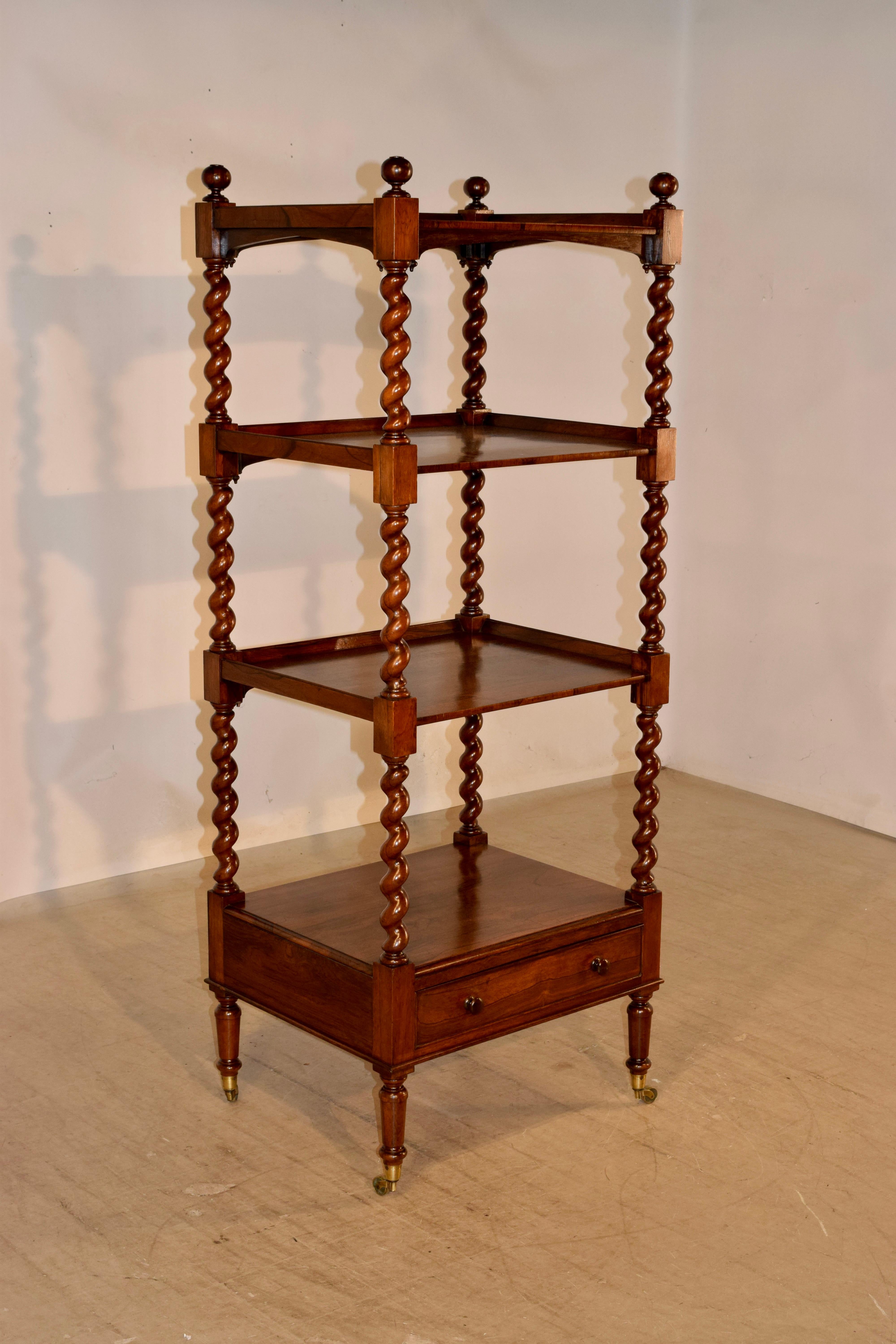 19th century rosewood whatnot shelf from England with three shelves with galleries, all separated by hand turned barley twist shelf supports, over a lower shelf which has a single drawer beneath it. The piece is raised on hand turned legs on what