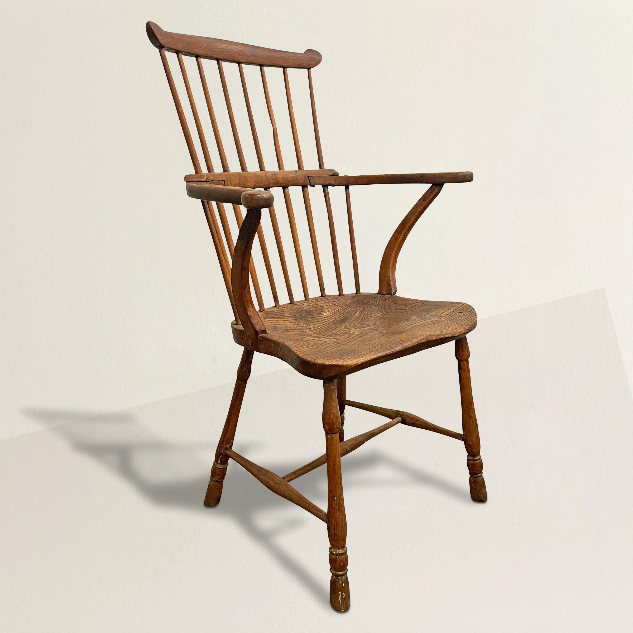 A beautiful 19th century English ash and oak comb-back Windsor chair with out-turned arms supported by inverted stretchers, turned legs connected by a bentwood stretcher, and a solid oak seat. The seat is one piece of wood with a beautiful patina,