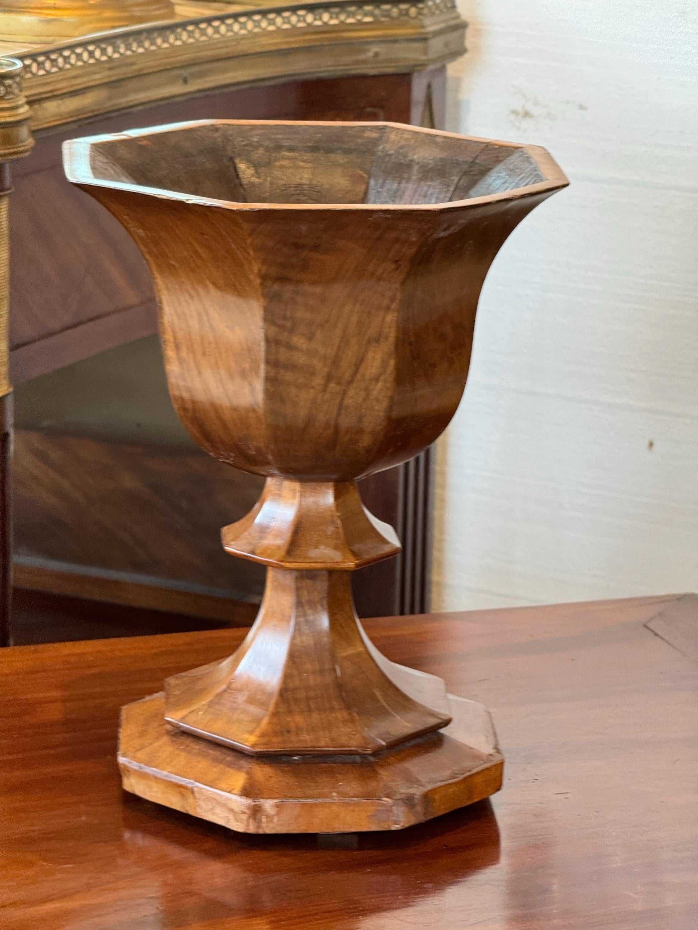 A wooden urn with pretty veneers. Great on a table.