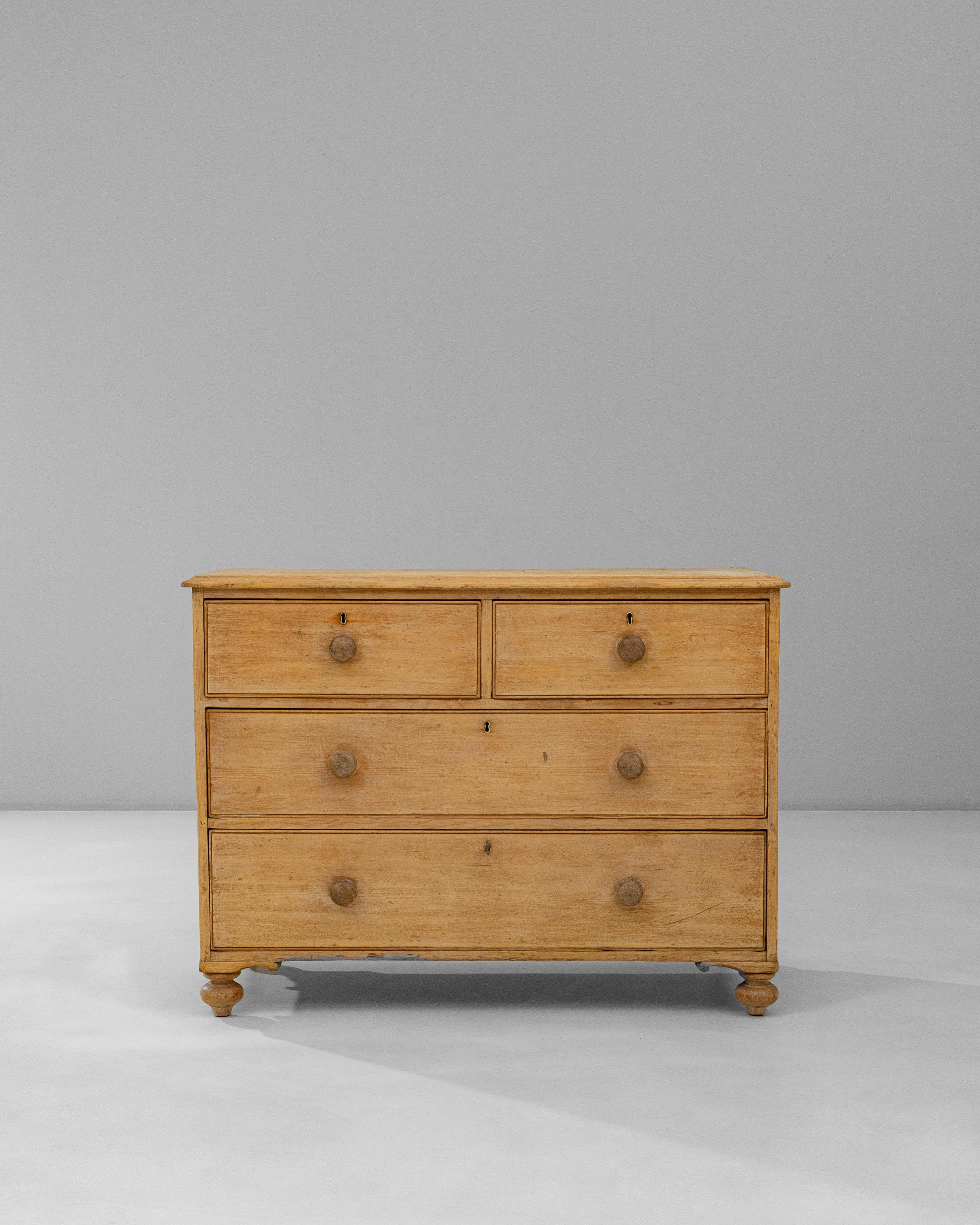 19th Century English Wooden Chest of Drawers. This charming English chest from the 19th century features a warm, natural patina that highlights the soft grain and subtle variations of its wooden surface. The simple, functional design includes two