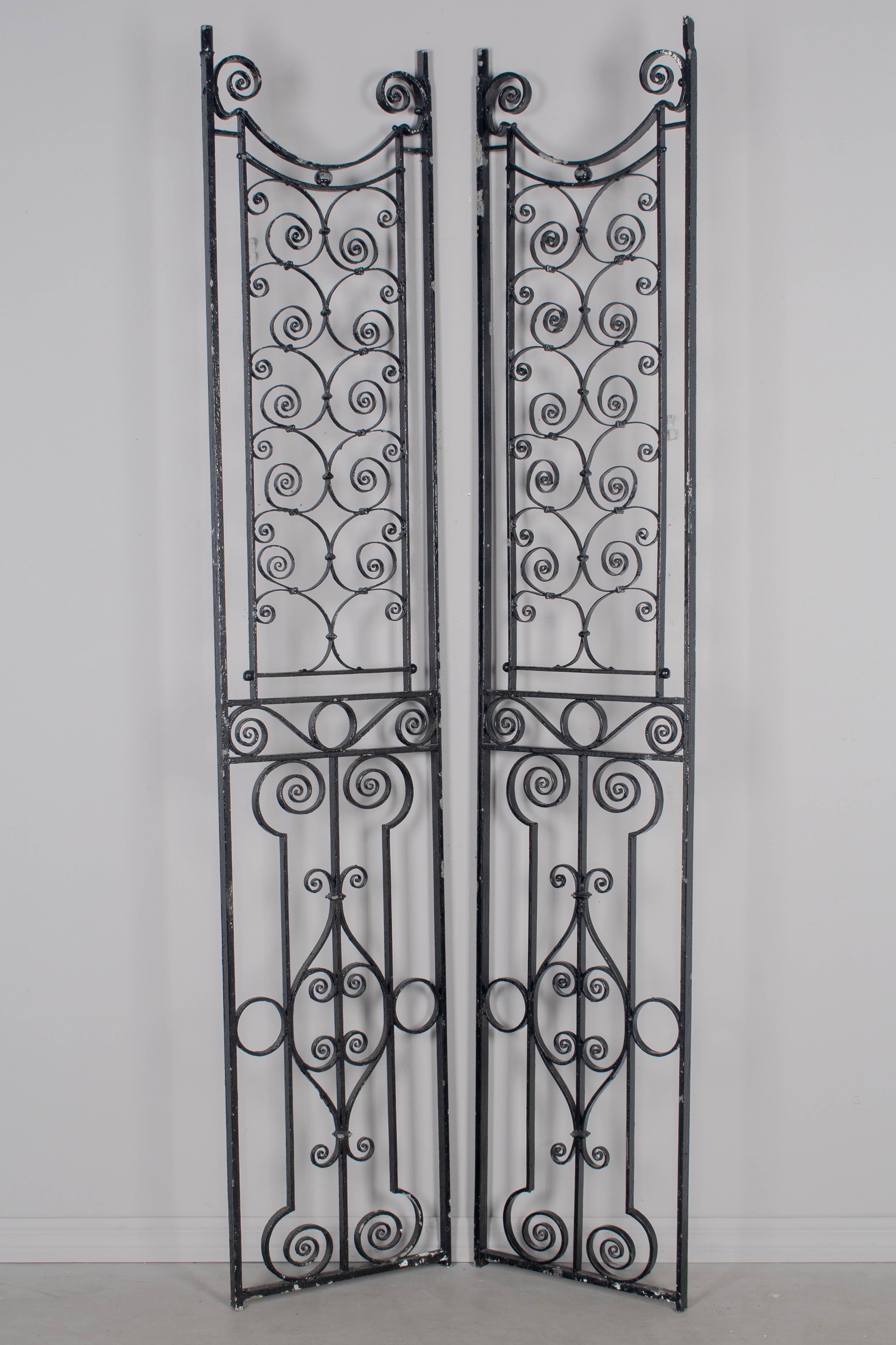 Coppia di pannelli decorativi in ferro battuto inglese del XIX secolo con patina nera. Lavoro in ferro di buona qualità. Alcune perdite di vernice. Si tratta di griglie recuperate da un vecchio ascensore di un hotel.  Sono perfetti per essere