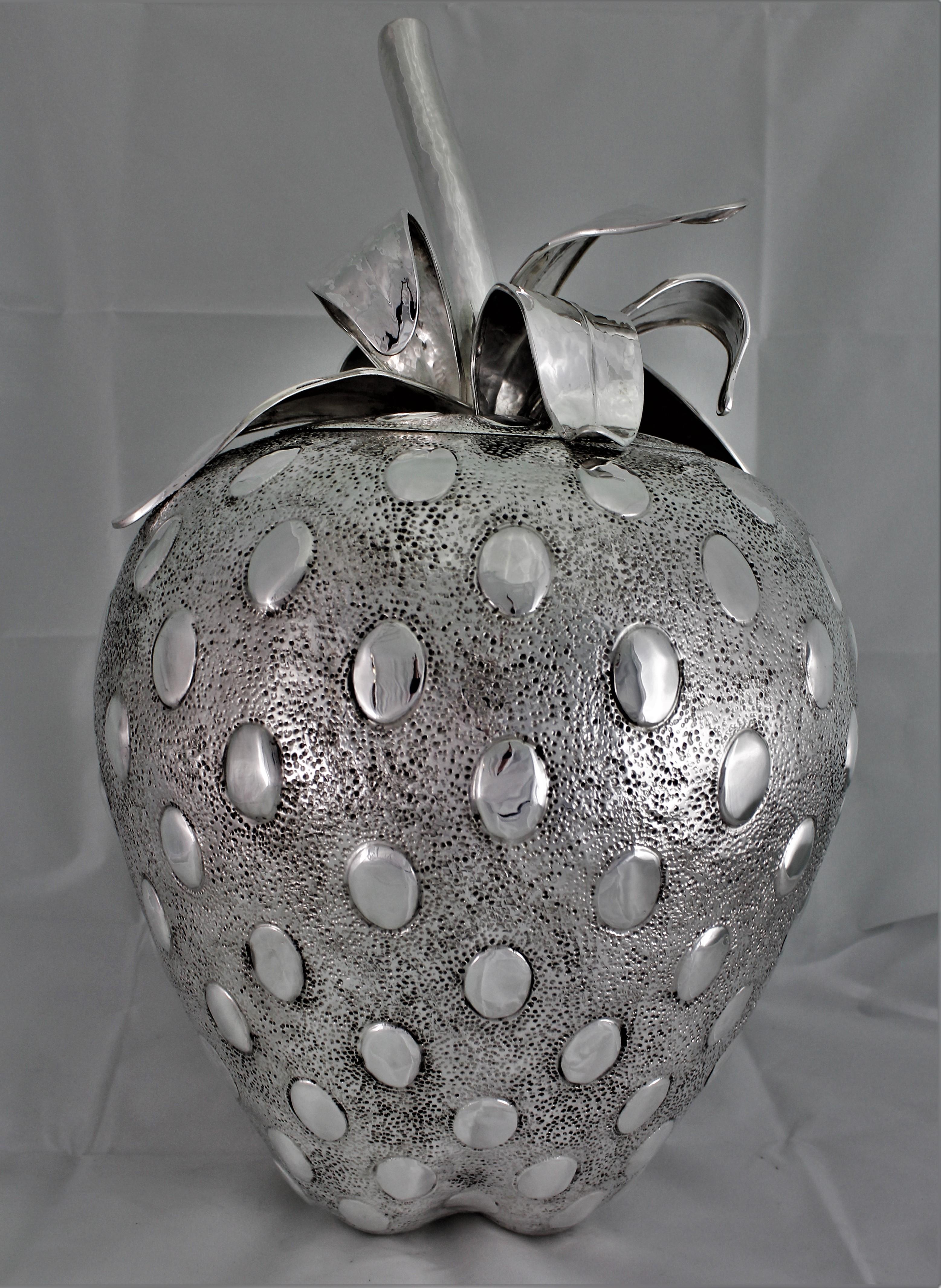 Impressive embossed and engraved silver centerpiece strawberry shaped.

Entirely embossed and shaped by hand, beautifully engraved in every detail like a real strawberry.

Upper part is a cover, with the strawberry leaves and stem as