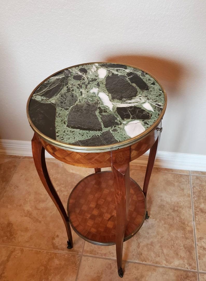 A gorgeous antique Louis XV style side table by Escalier de Cristal with beautiful patina. Hand crafted in Paris France during the last quarter of the 19th century, it features a verde marble-top, above a diamond motif parquet case with a single
